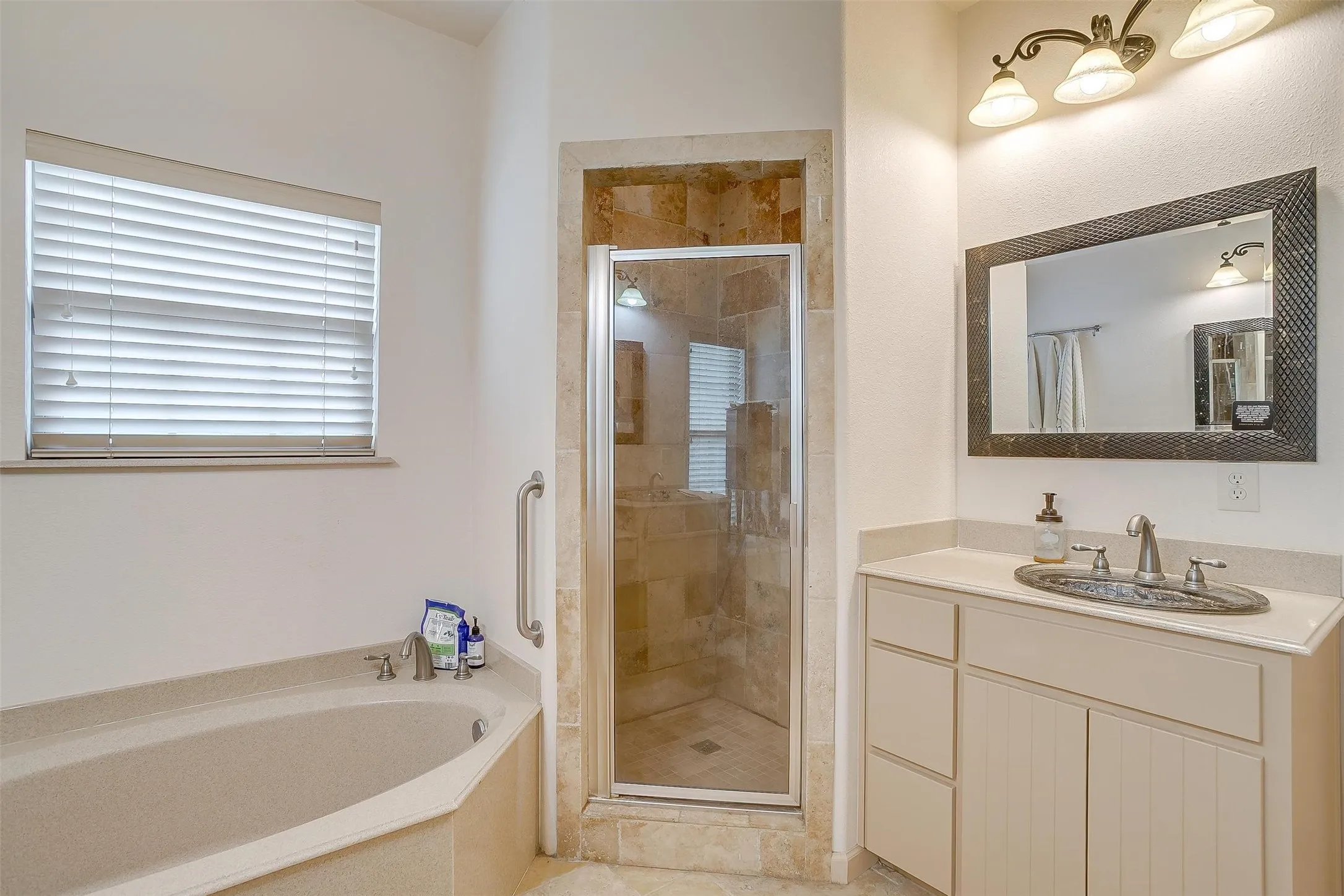 Full bathroom with a stall shower, a garden tub, and vanity