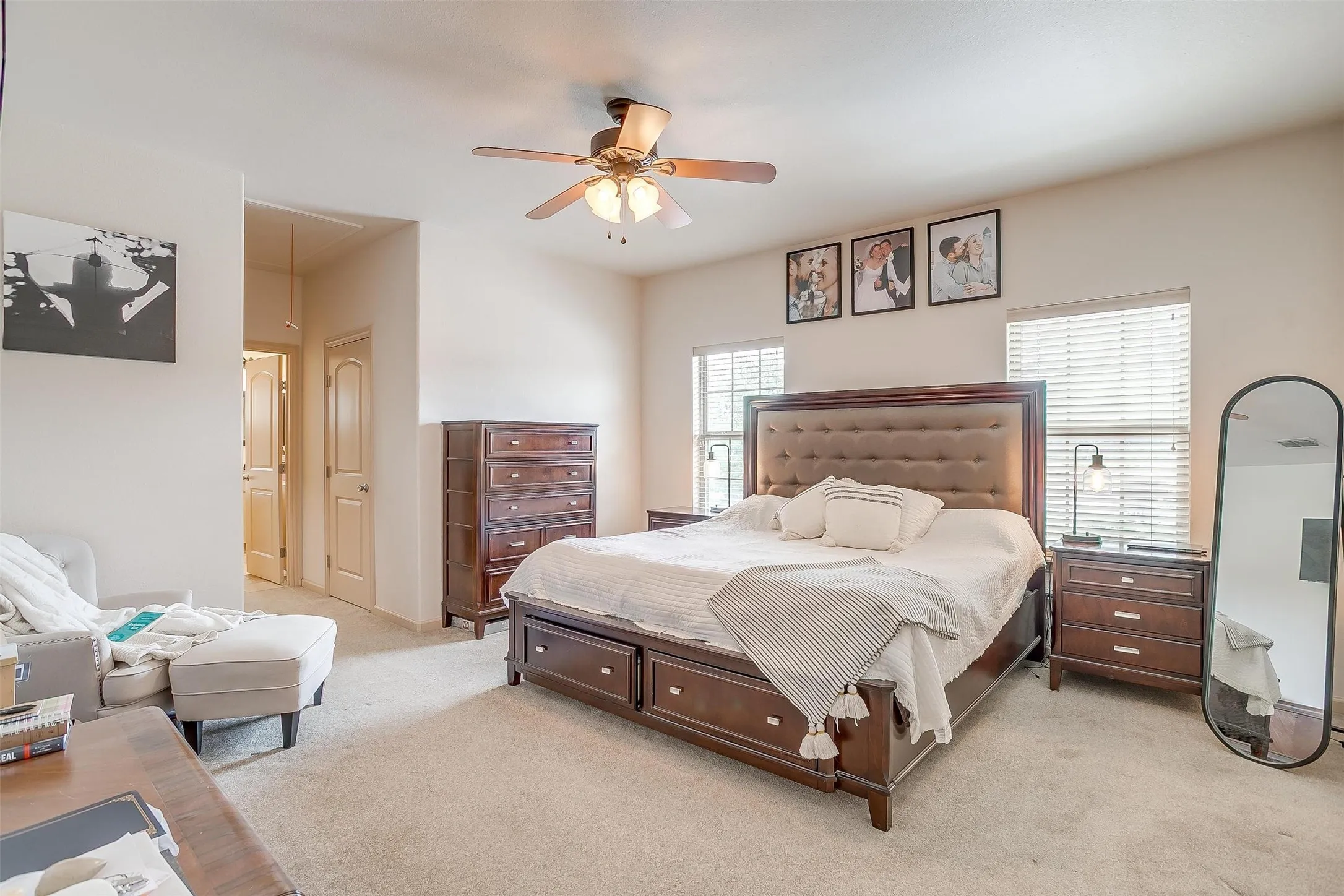Bedroom with attic access, light carpet, and a ceiling fan