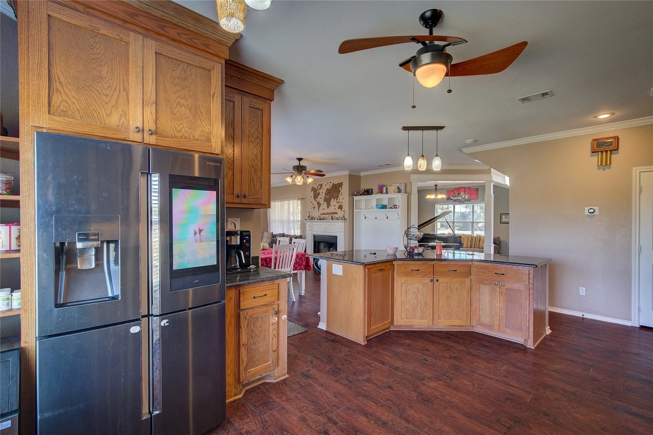 Kitchen featuring stainless steel fridge, dark wood-type flooring, and ornamental molding