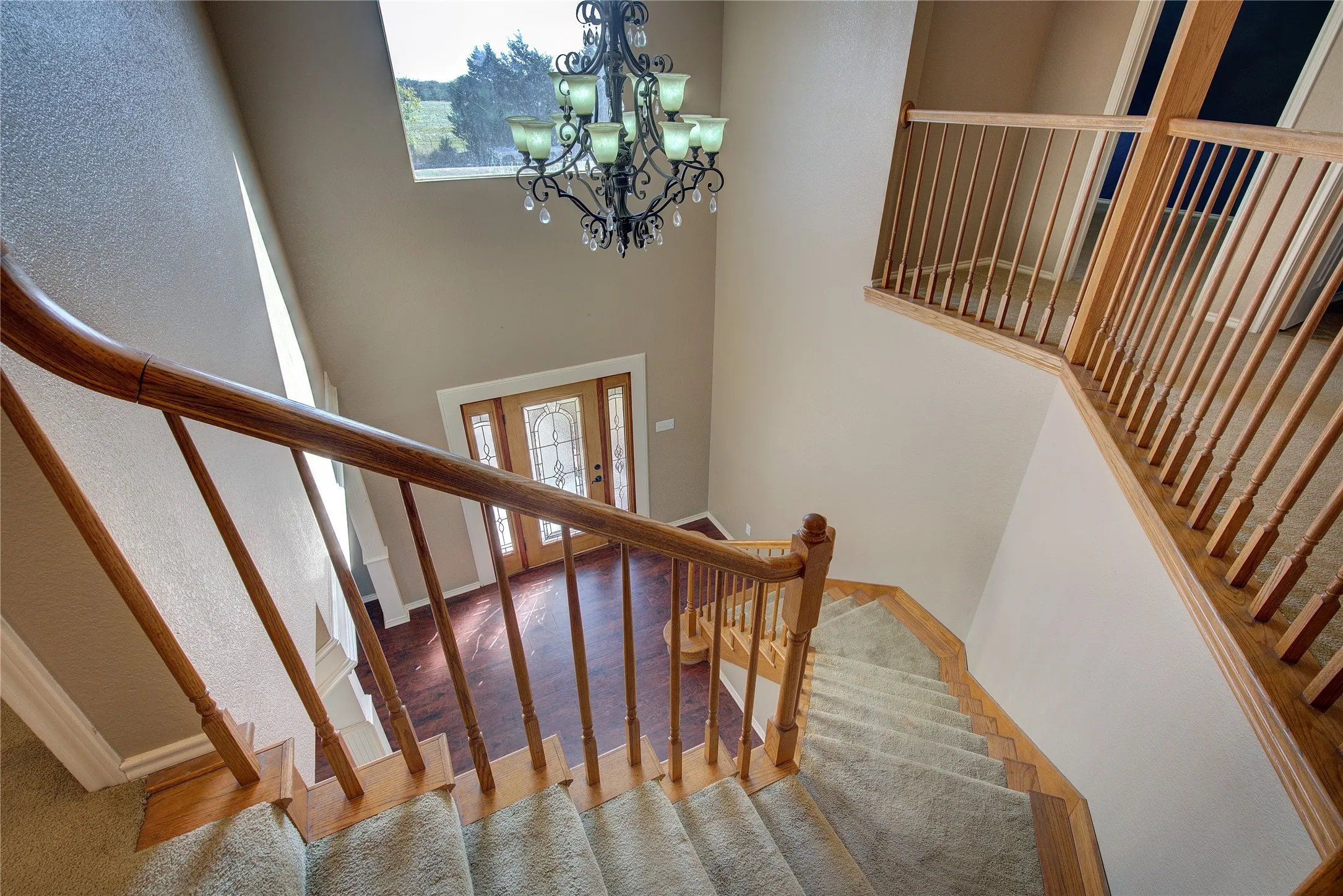 Staircase with a towering ceiling and an inviting chandelier