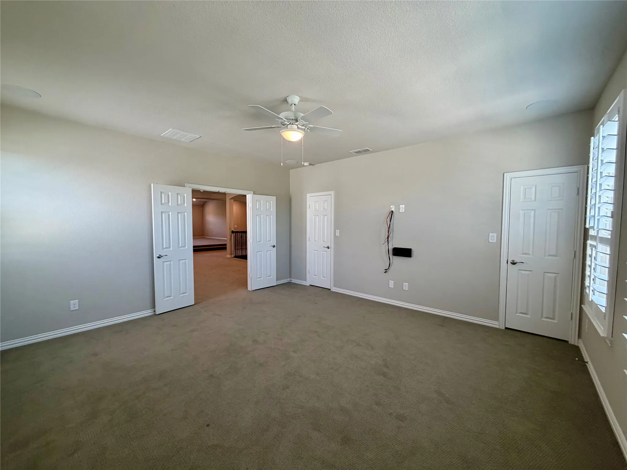 Media bedroom featuring carpet floors and a ceiling fan