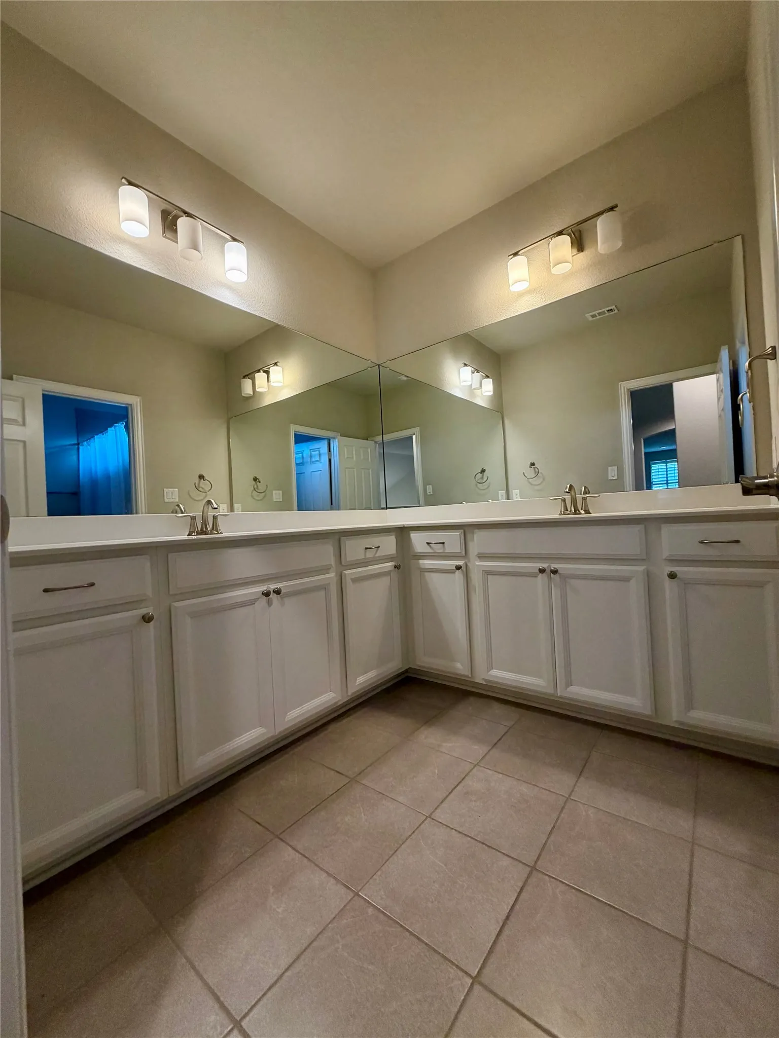 Bathroom featuring light tile patterned floors and double vanity
