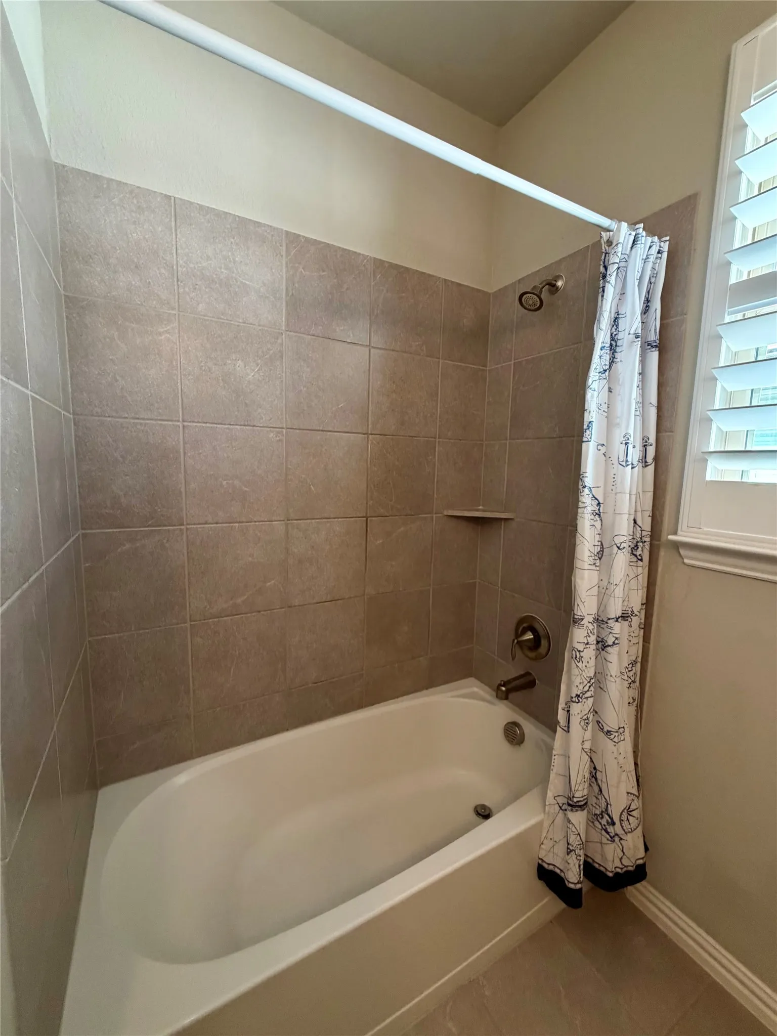 Full bathroom with shower / bath combination with curtain and tile patterned floors