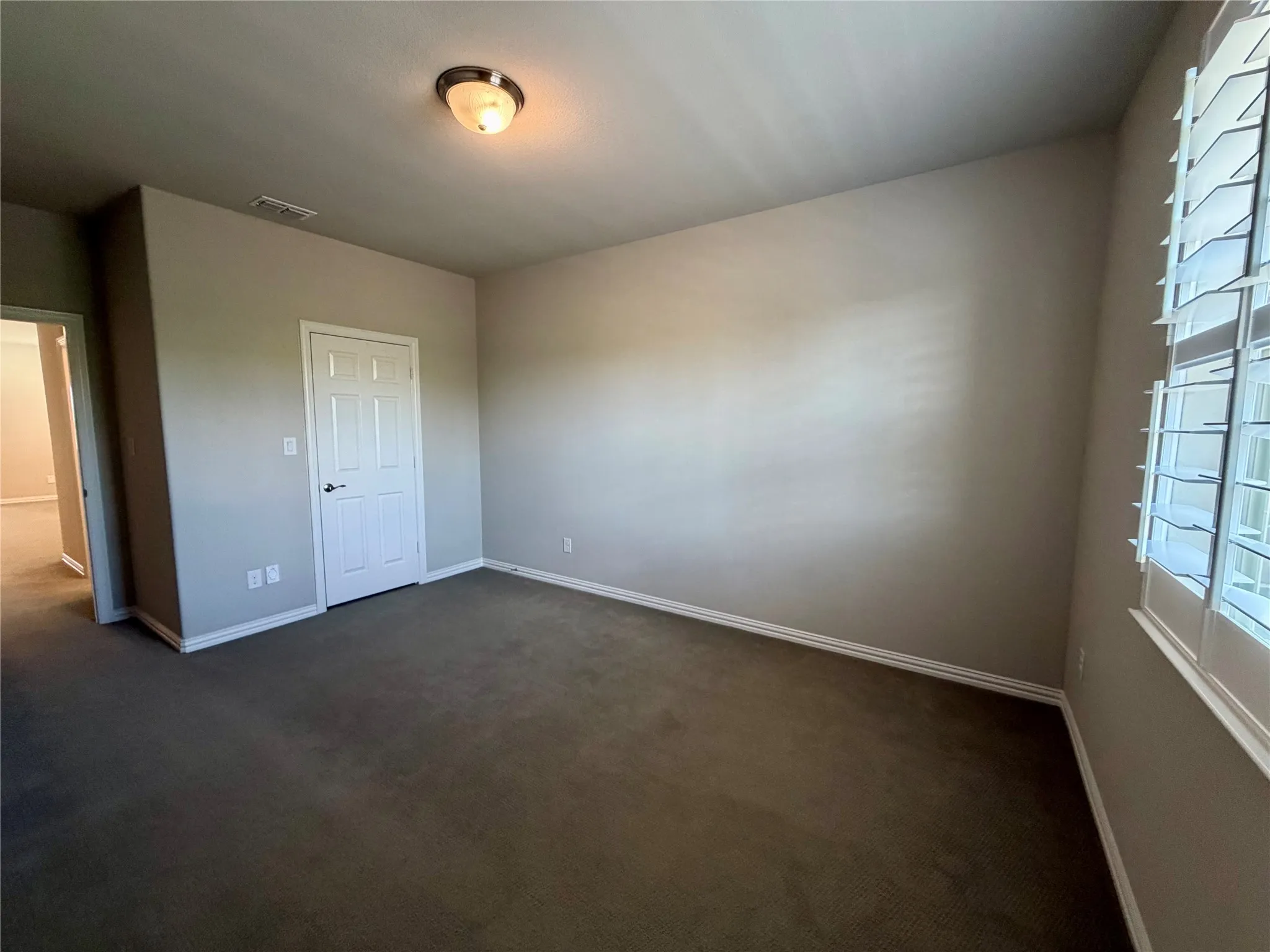 Unfurnished bedroom featuring dark carpet