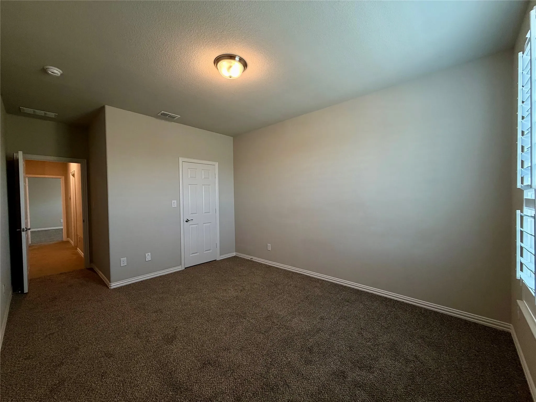 Unfurnished bedroom with carpet floors and a textured ceiling