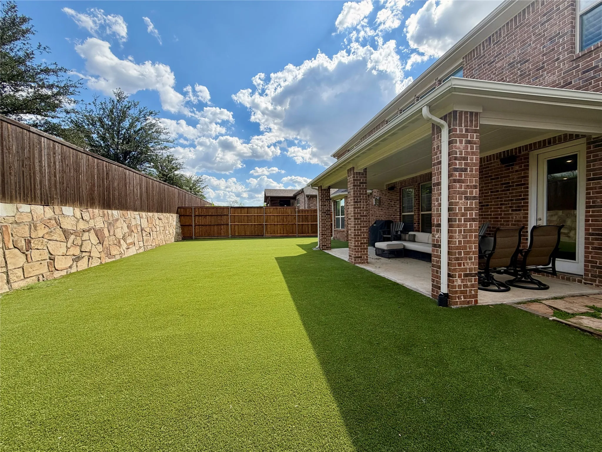 Fenced backyard with a patio and outdoor lounge area