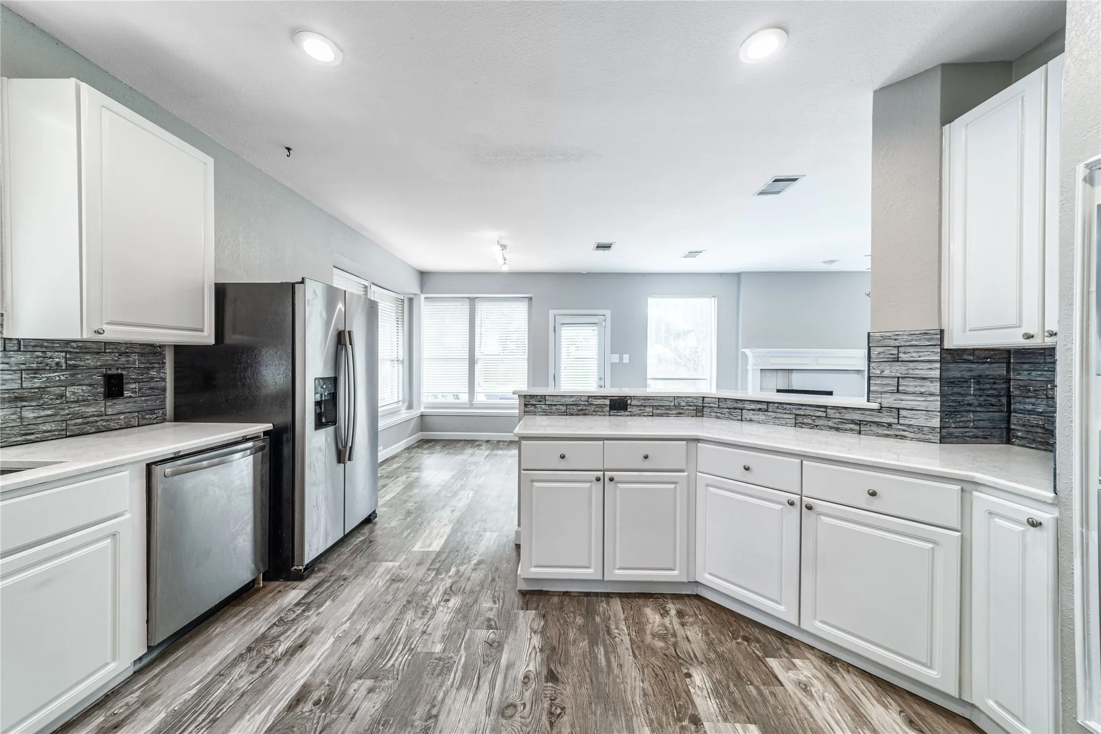 Kitchen featuring backsplash, white cabinetry, and stainless steel dishwasher
