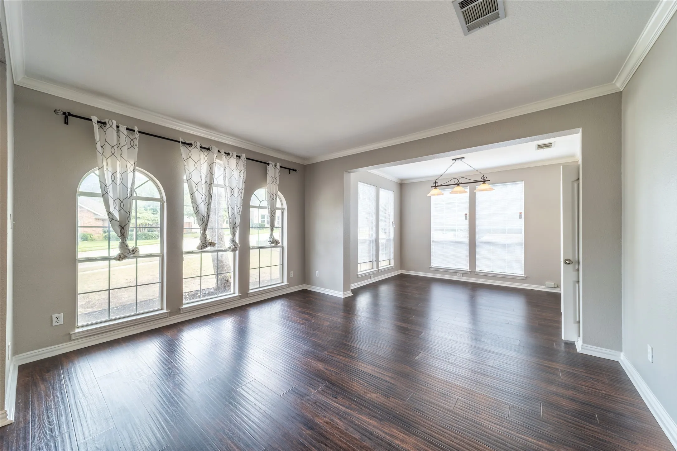 dining-living room featuring crown molding and dark wood-style flooring