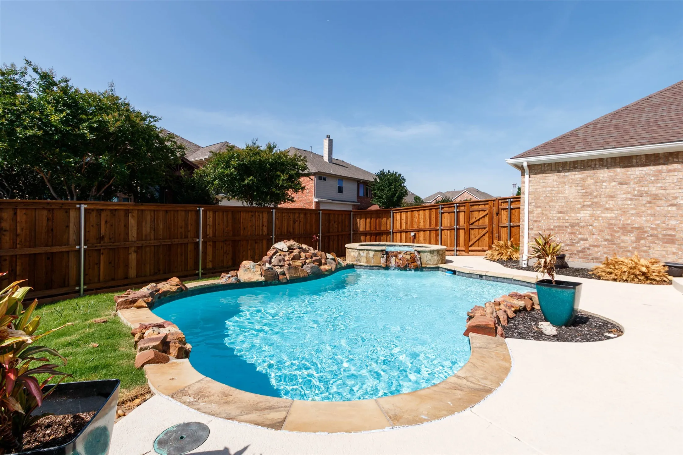 View of pool featuring a fenced backyard, a patio, and a pool with connected hot tub