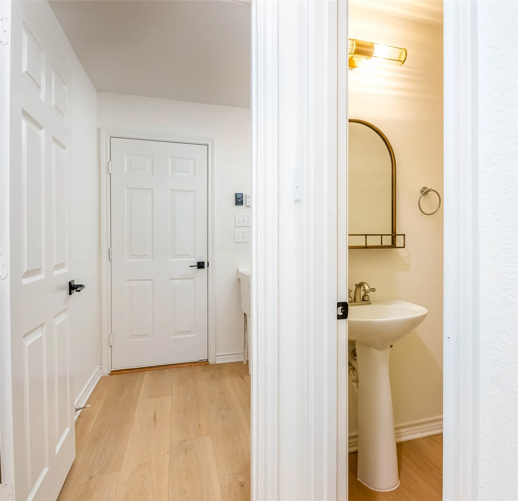 Half bath with light wood-style flooring and baseboards