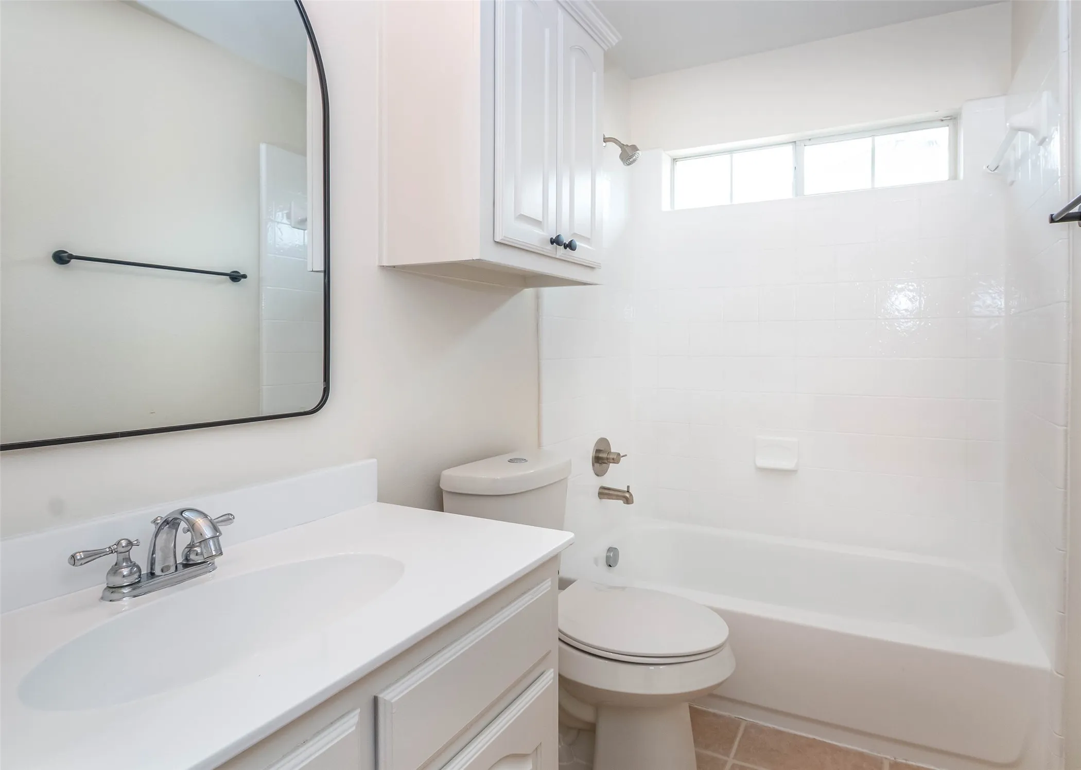 Bathroom featuring shower / bathtub combination, vanity, and light tile patterned floors
