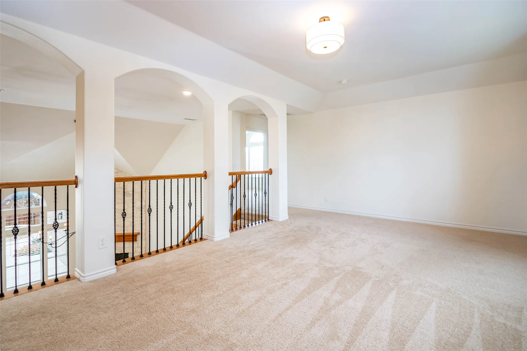 Carpeted spare room featuring healthy amount of natural light and vaulted ceiling
