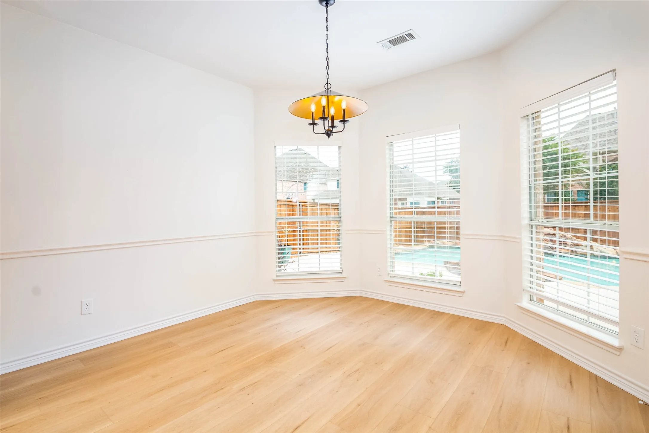Unfurnished room with light wood-style floors and a chandelier
