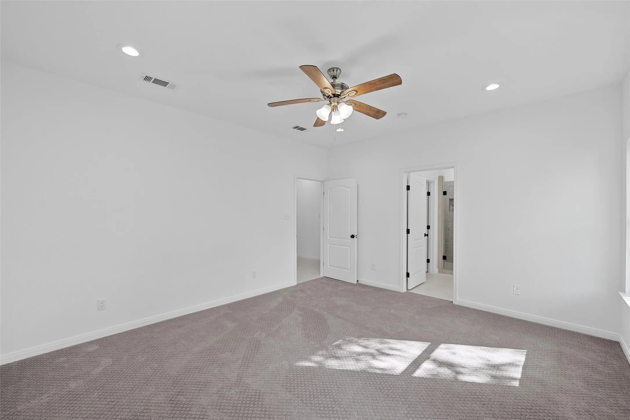 Unfurnished primary bedroom with recessed lighting, carpet floors, and ceiling fan