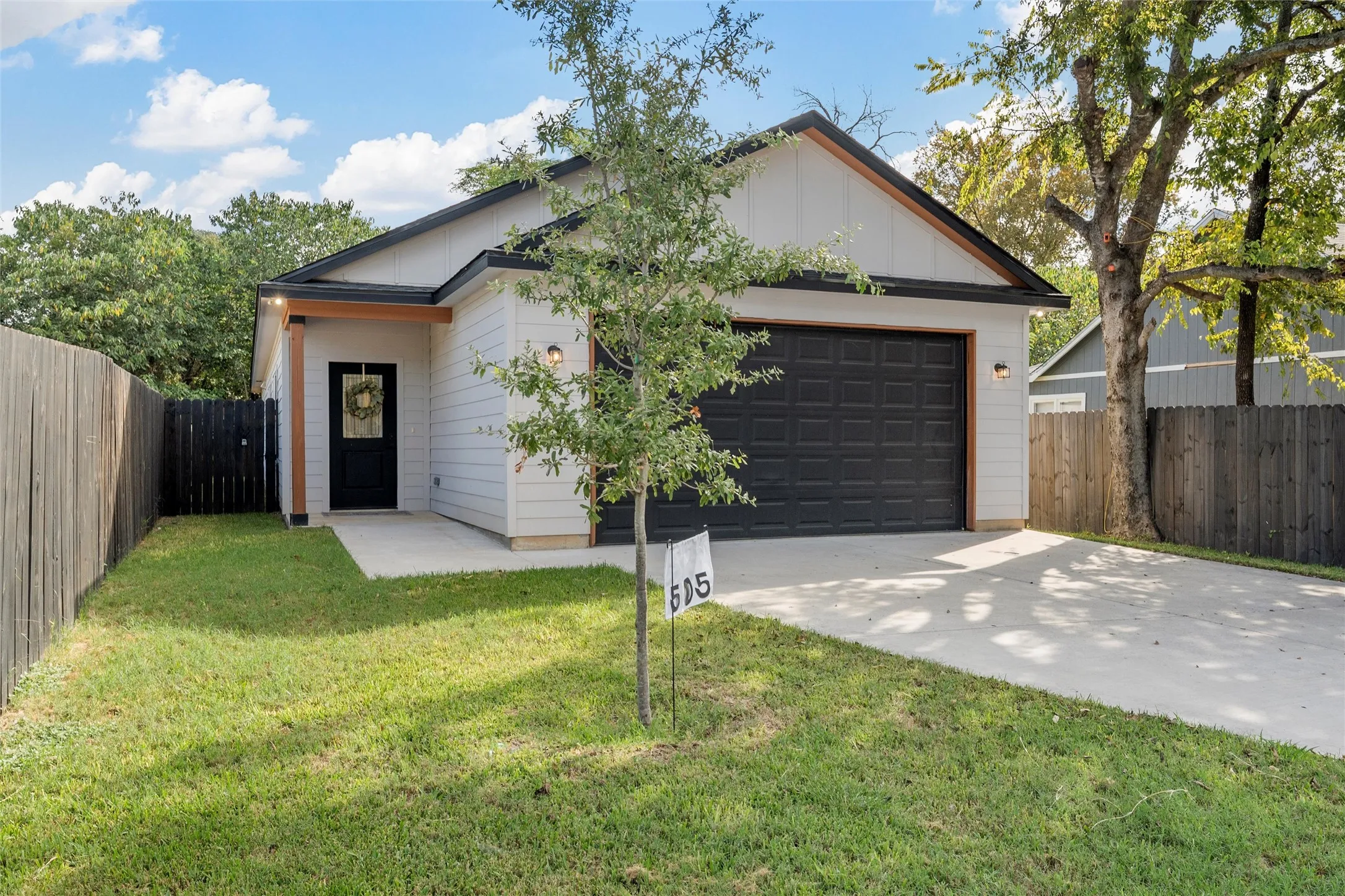 View of front of property featuring extended driveway and large garage