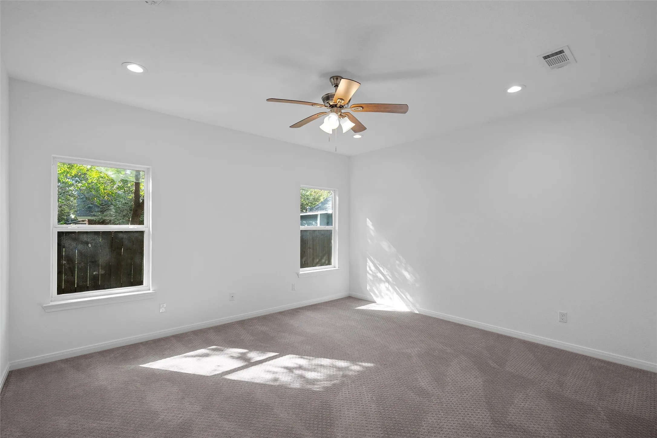 Ample primary bedroom with recessed lighting and a ceiling fan