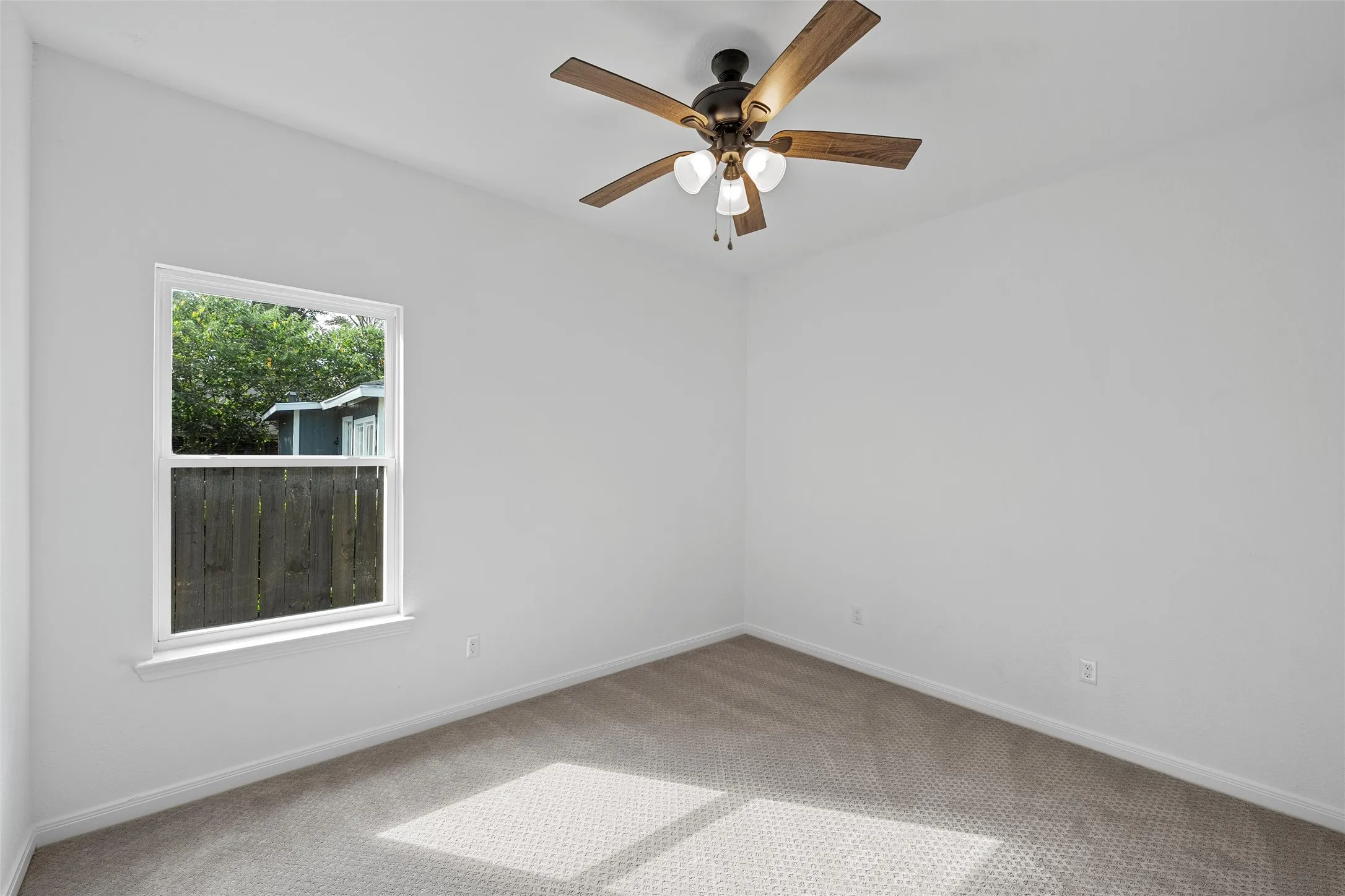 Carpeted room featuring baseboards and a ceiling fan