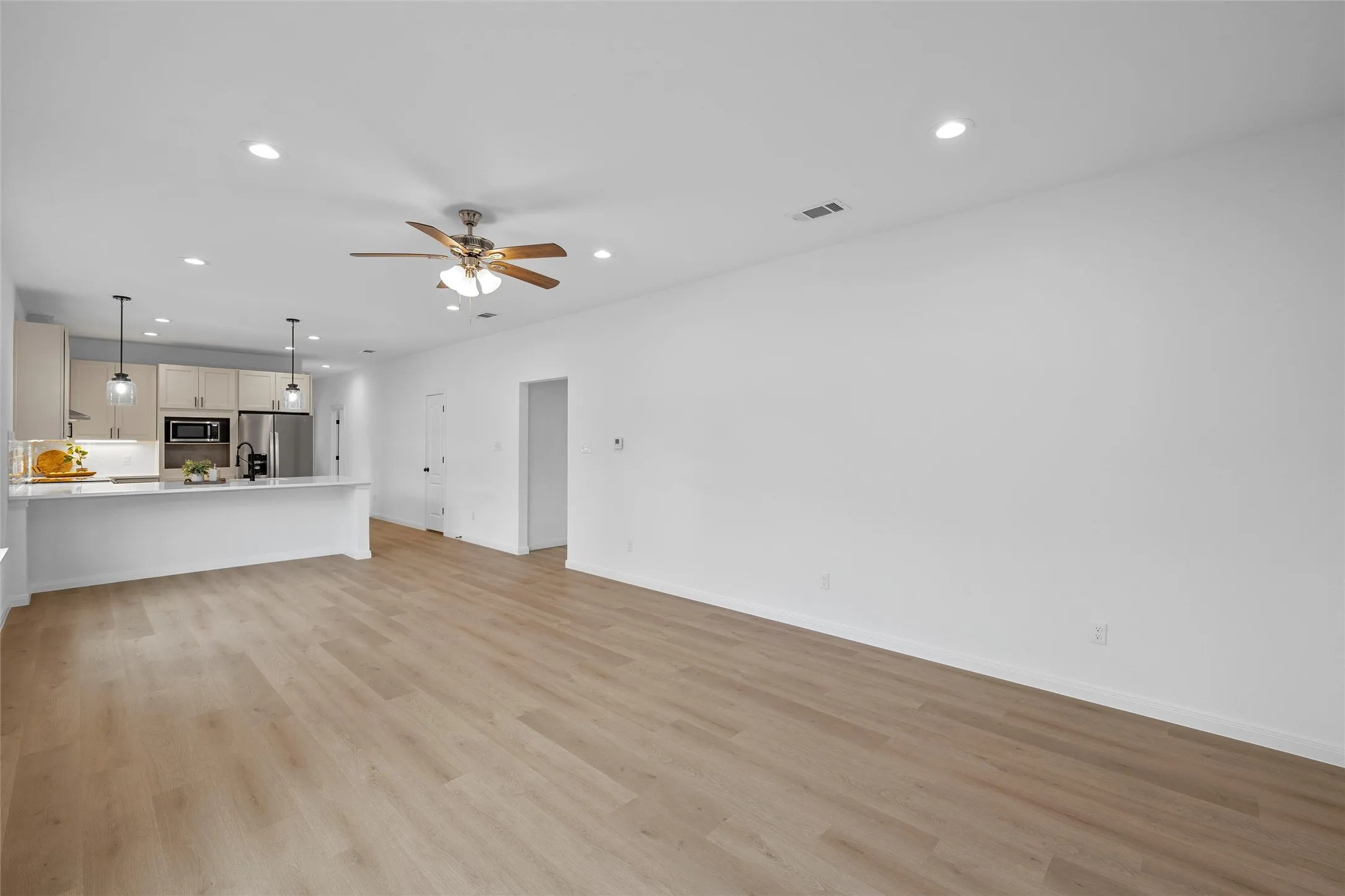 Unfurnished living room featuring recessed lighting, light wood-style floors, and ceiling fan