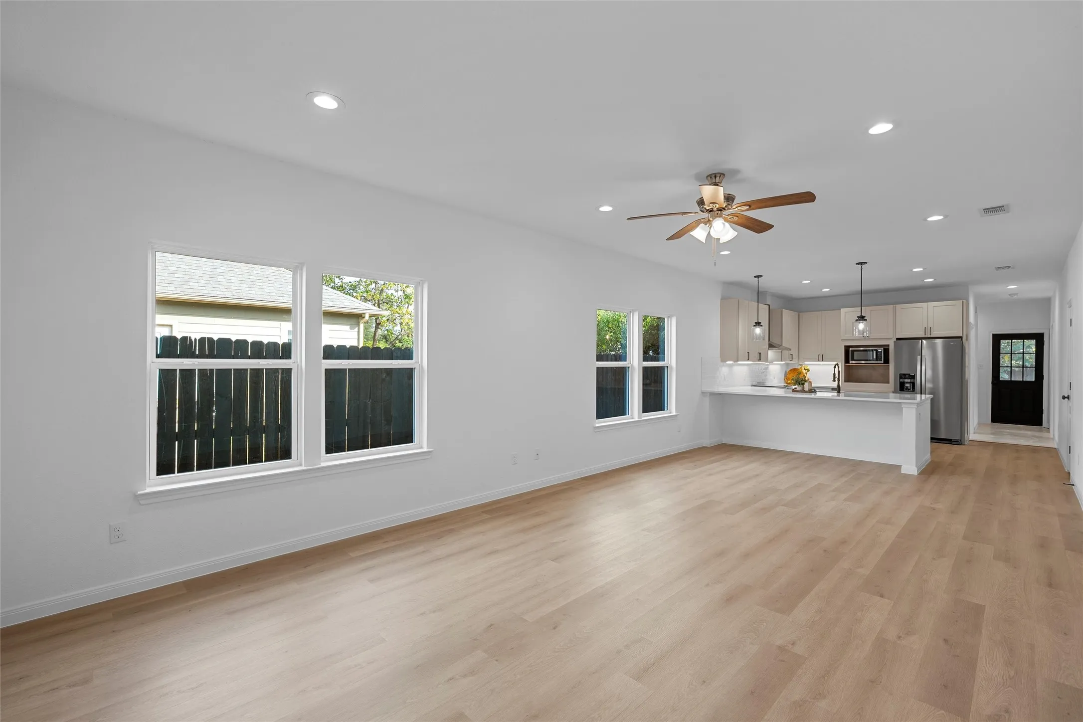 Unfurnished living room featuring recessed lighting, plenty of natural light, light wood-style flooring, and ceiling fan