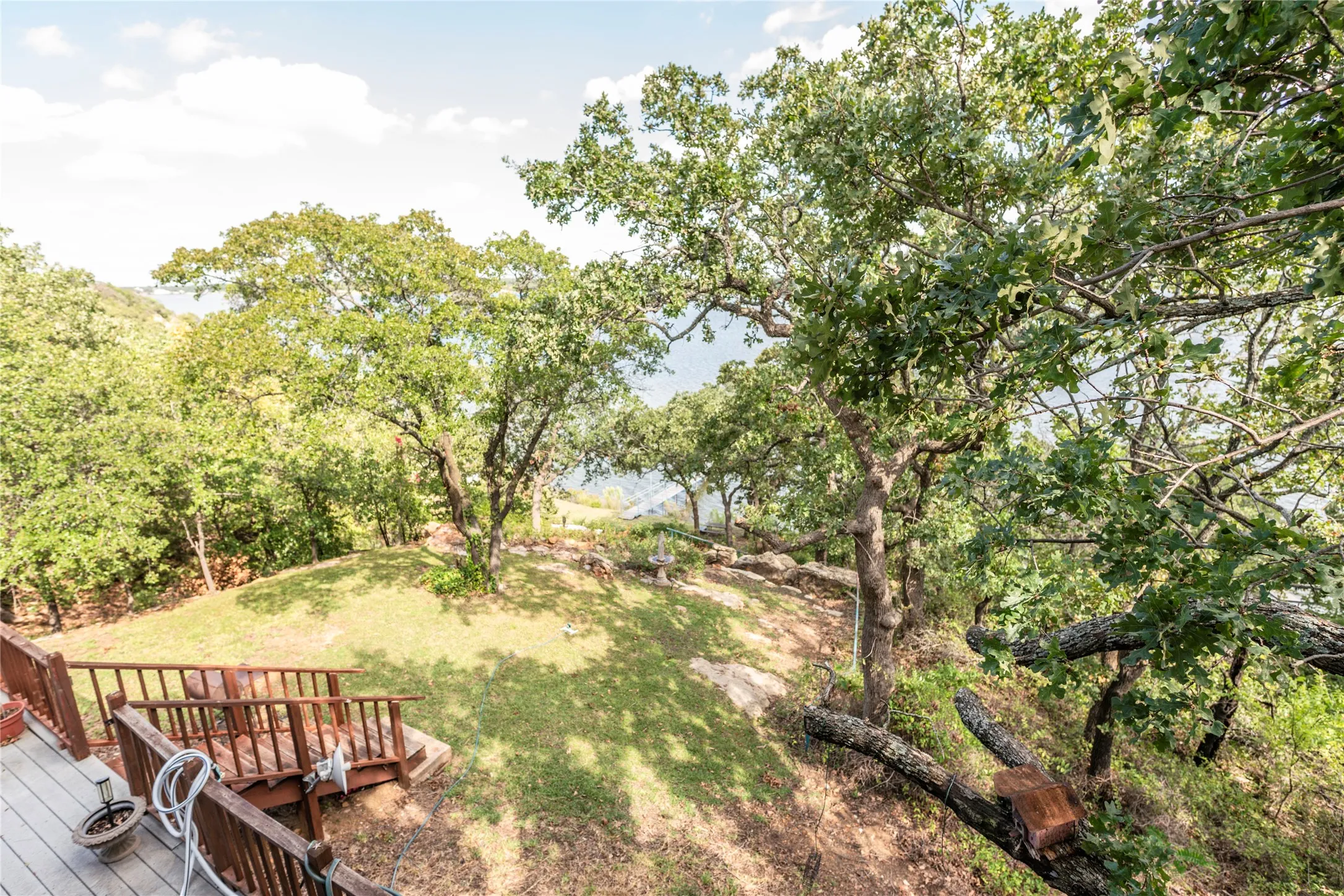 View of grassy yard with a wooden deck