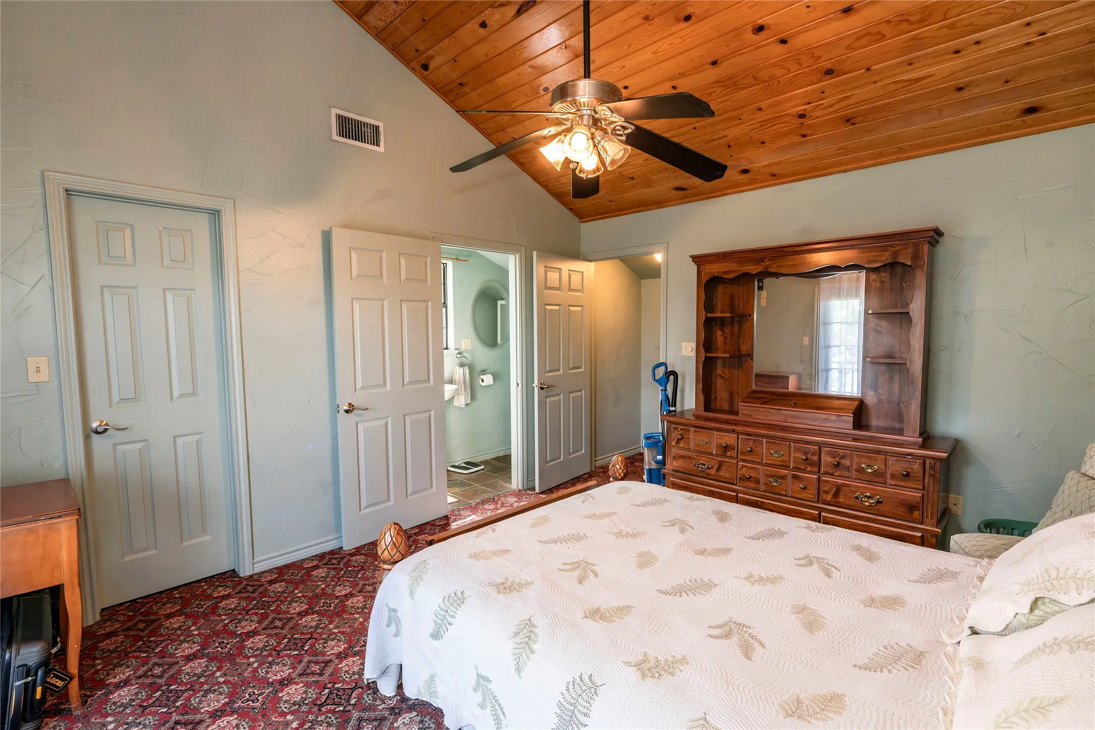 Bedroom featuring high vaulted ceiling, wood ceiling, ceiling fan, and dark colored carpet