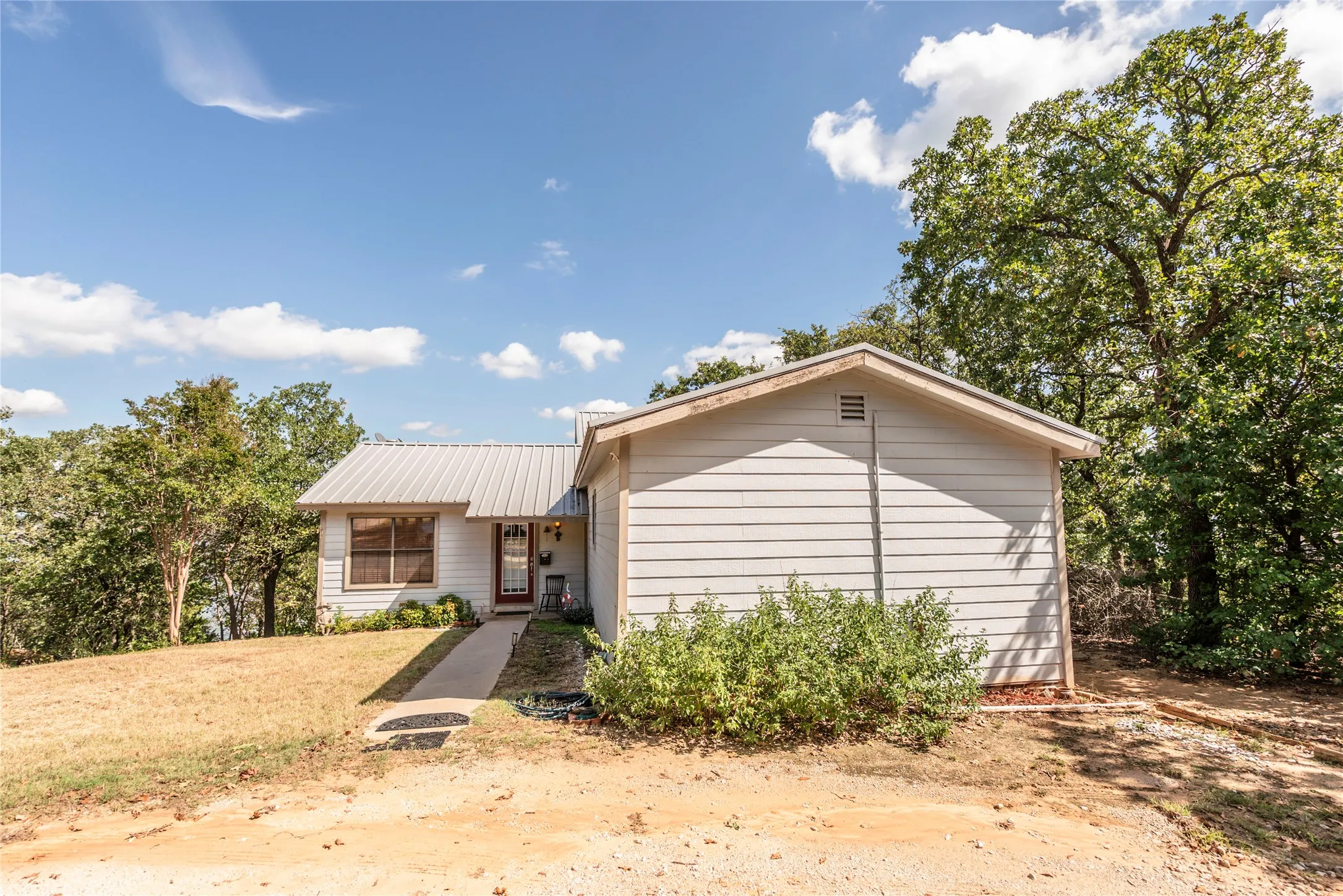 View of front of property featuring a front yard and a metal roof