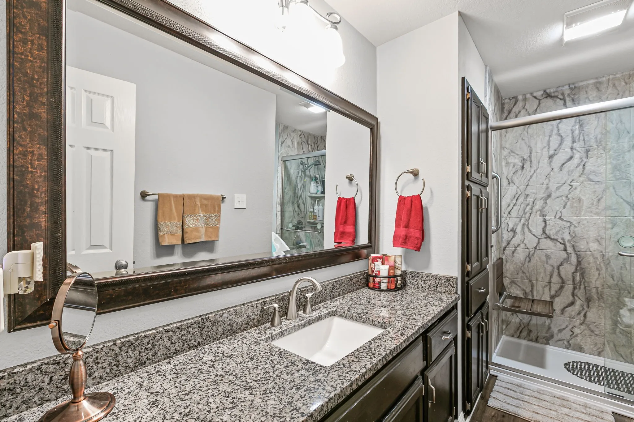Full bath with a marble finish shower and vanity