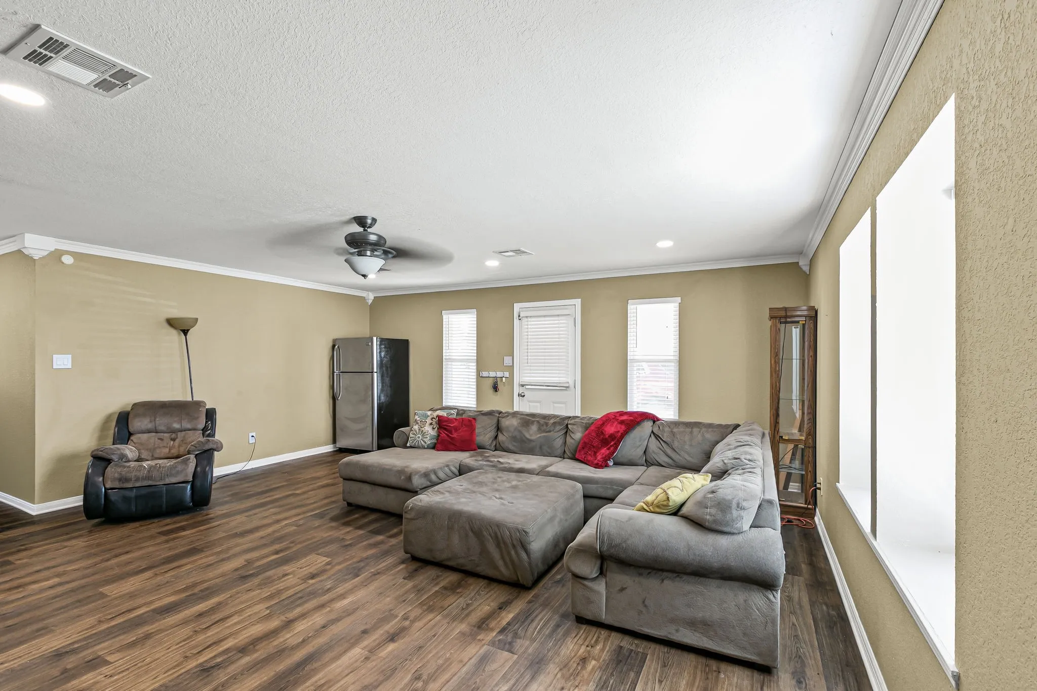 Living area featuring ornamental molding, dark wood-style flooring, recessed lighting, and ceiling fan