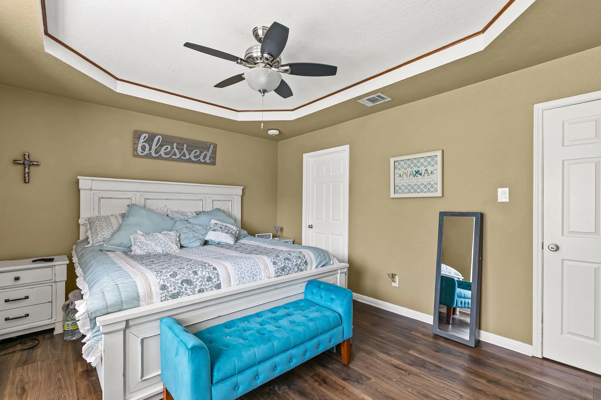 Bedroom featuring dark wood-style flooring, a tray ceiling, and a ceiling fan