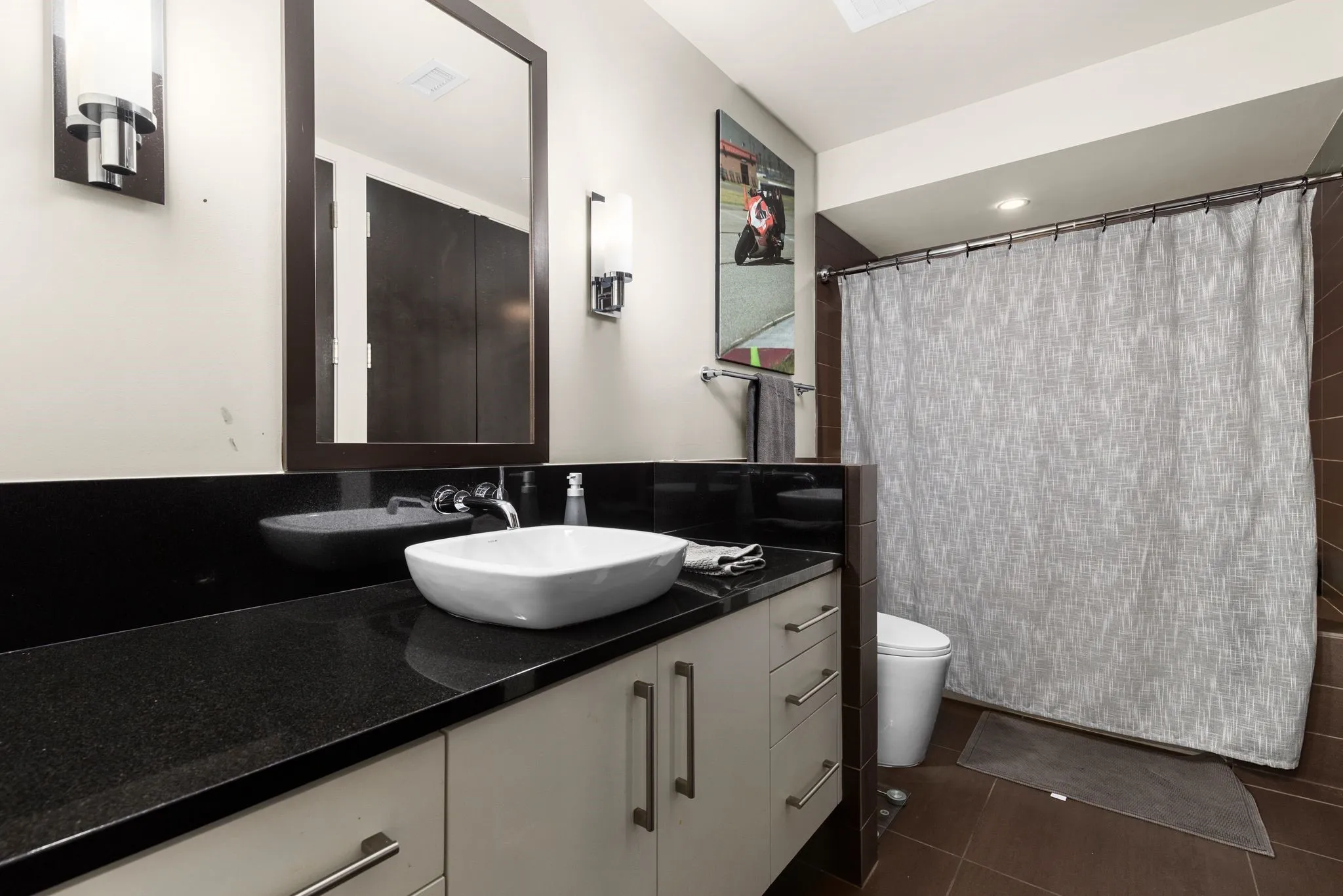 Full bathroom featuring vanity, a shower with curtain, and dark tile patterned flooring