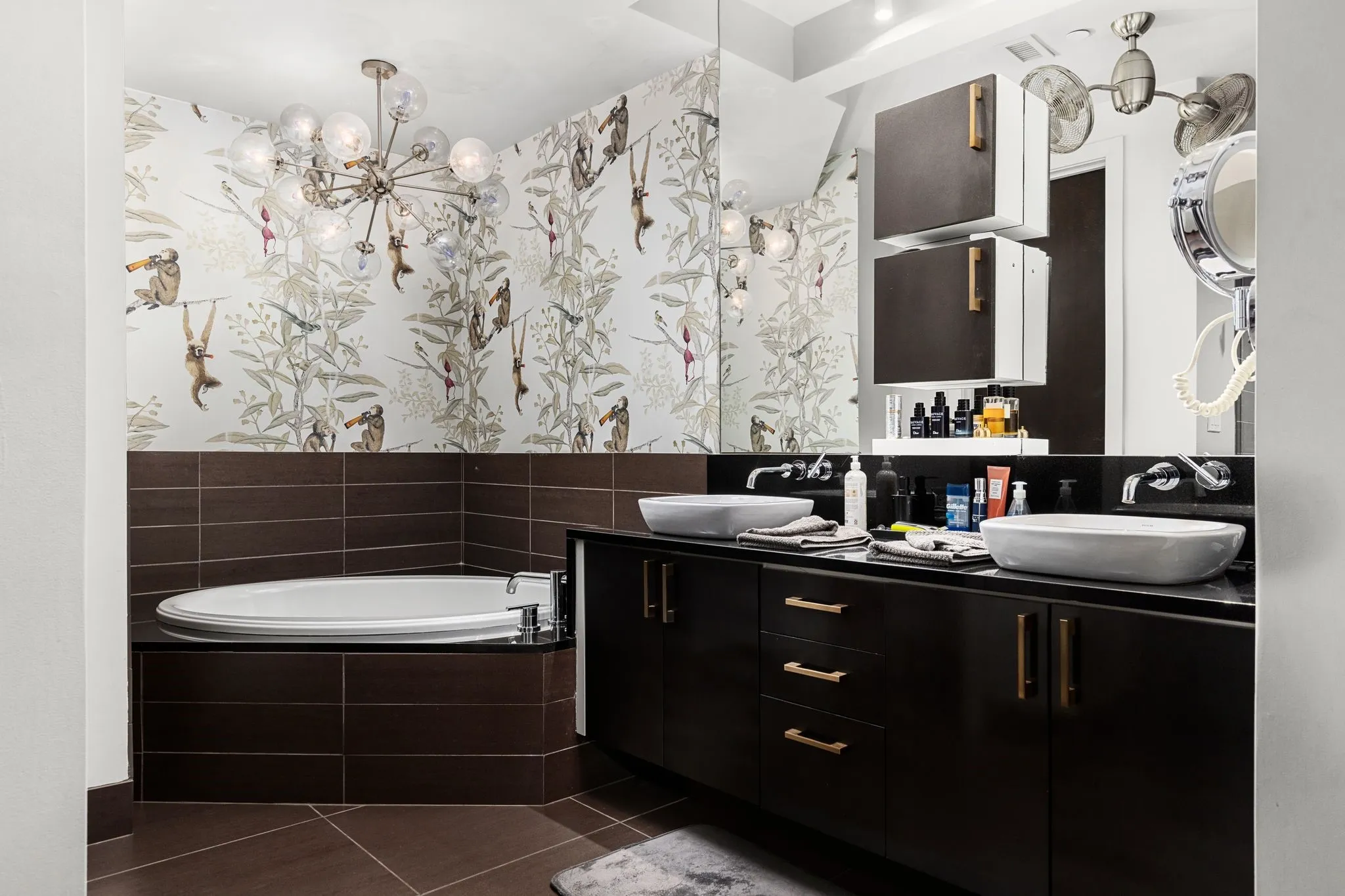 Full bathroom featuring dark tile patterned flooring, a garden tub, double vanity, and wallpapered walls