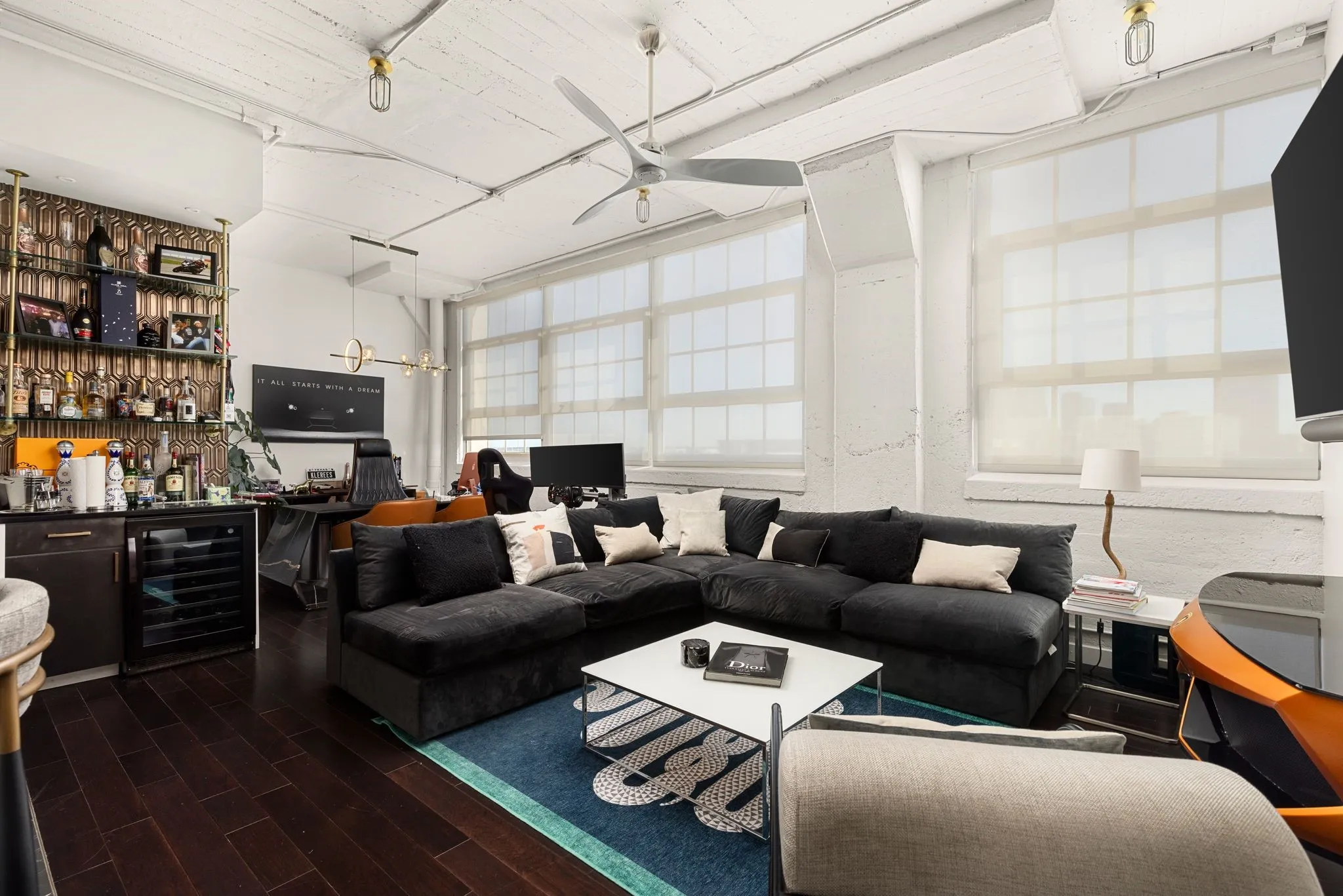 Living room featuring beverage cooler, ceiling fan, bar with sink, and wood finished floors