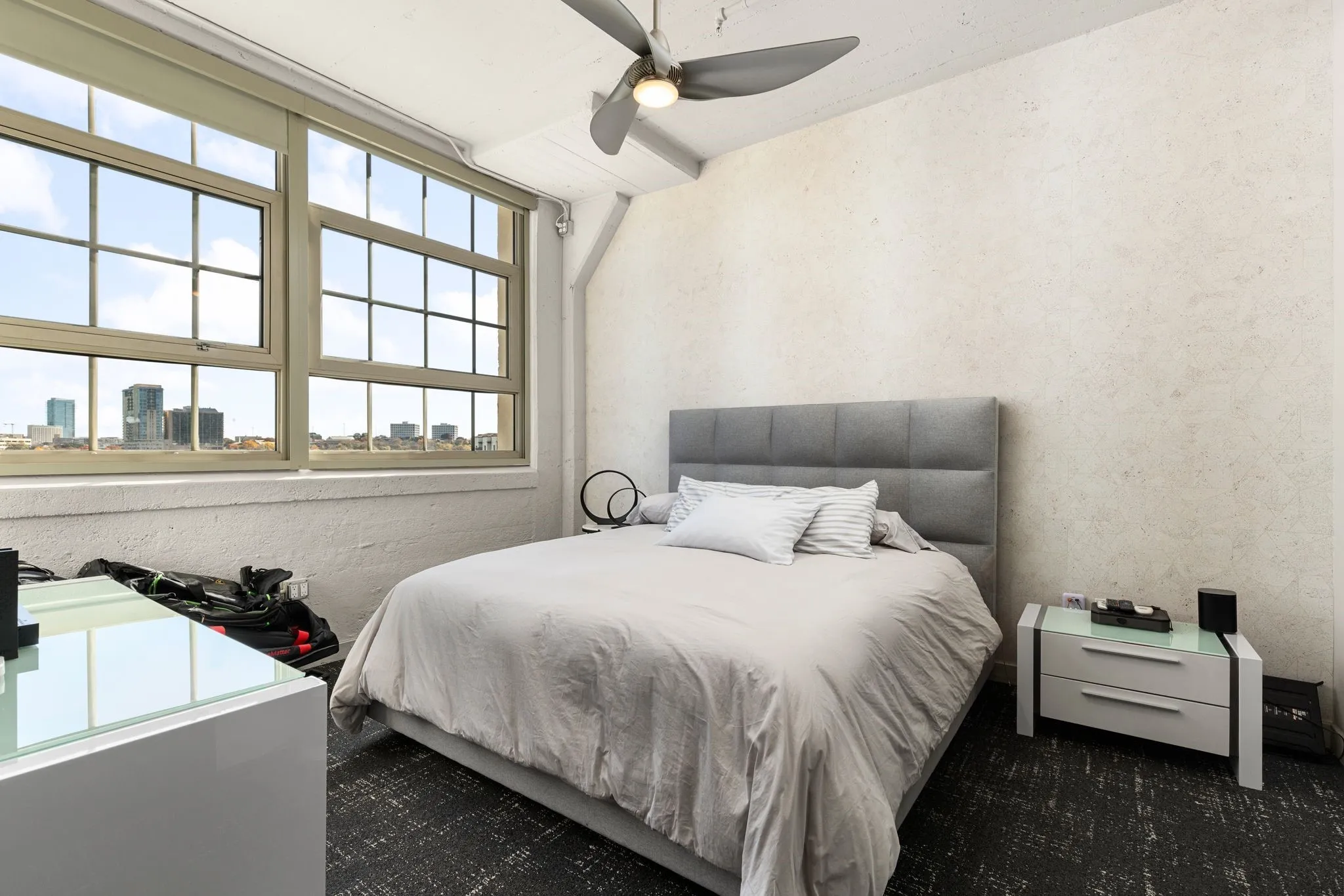 Bedroom with ceiling fan and a view of city