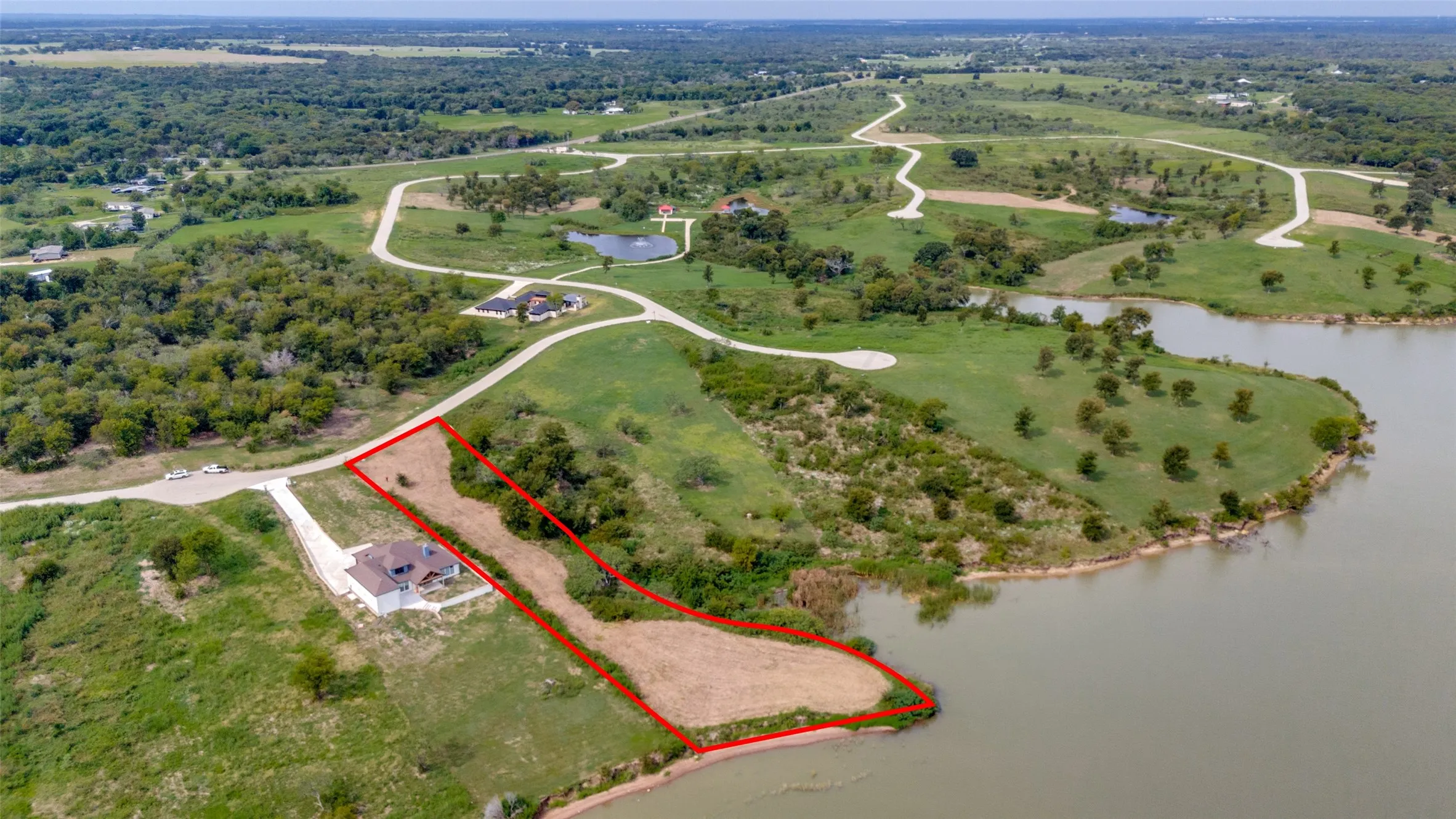 Aerial overview of property's location featuring property parcel outlined and a large body of water