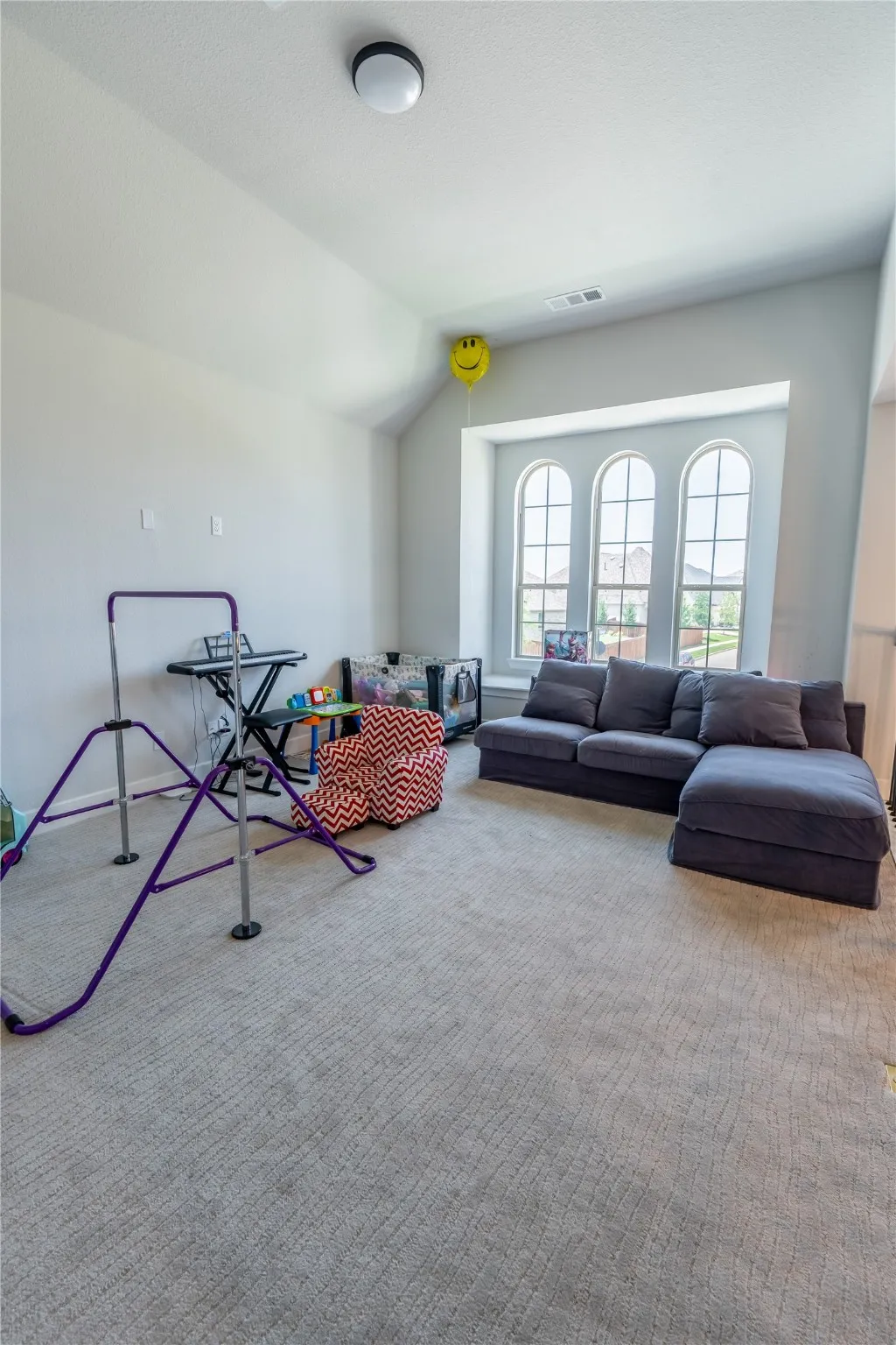 Recreation room featuring vaulted ceiling and carpet flooring