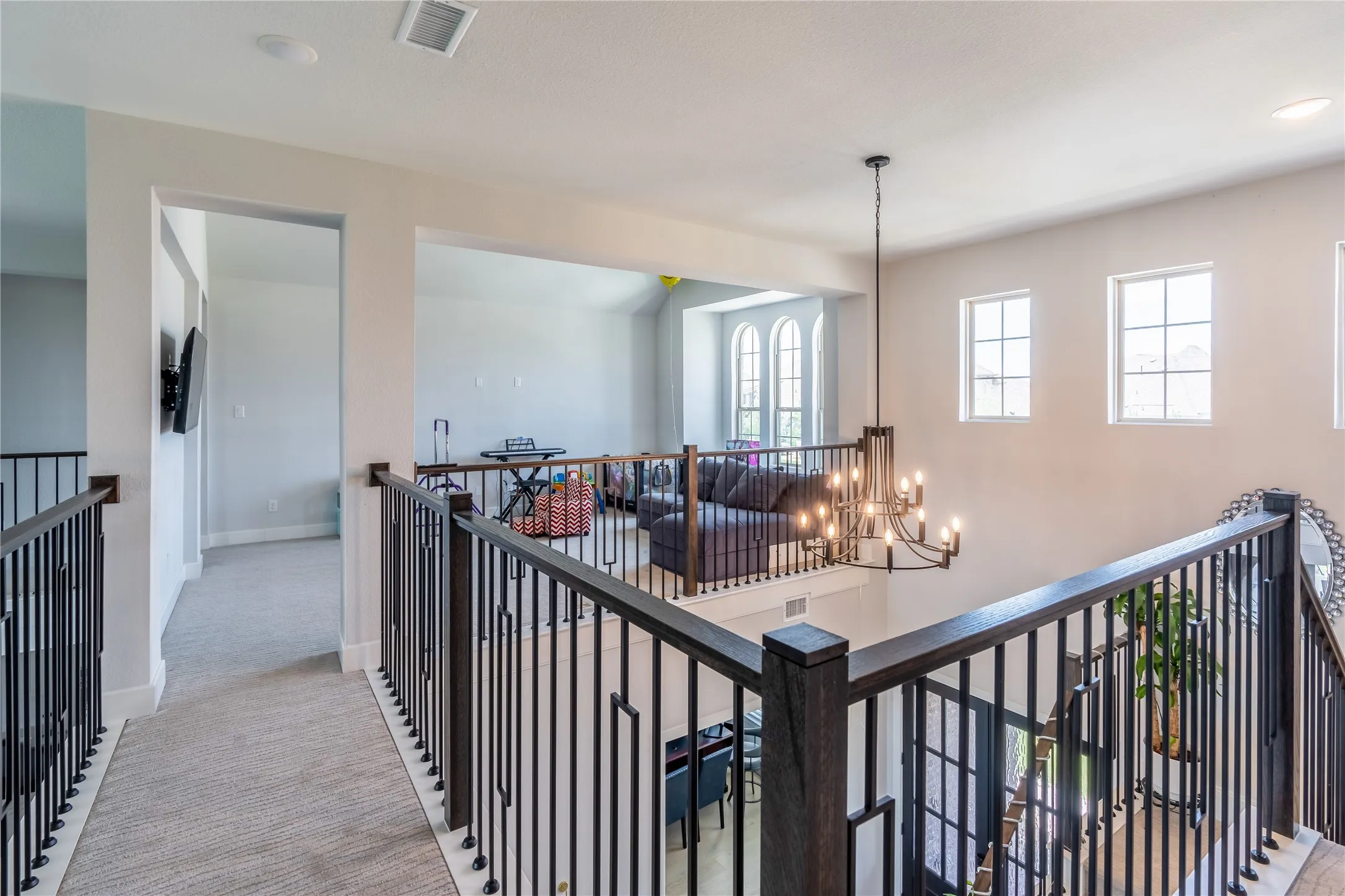 Hall featuring carpet floors, a chandelier, an upstairs landing, and recessed lighting