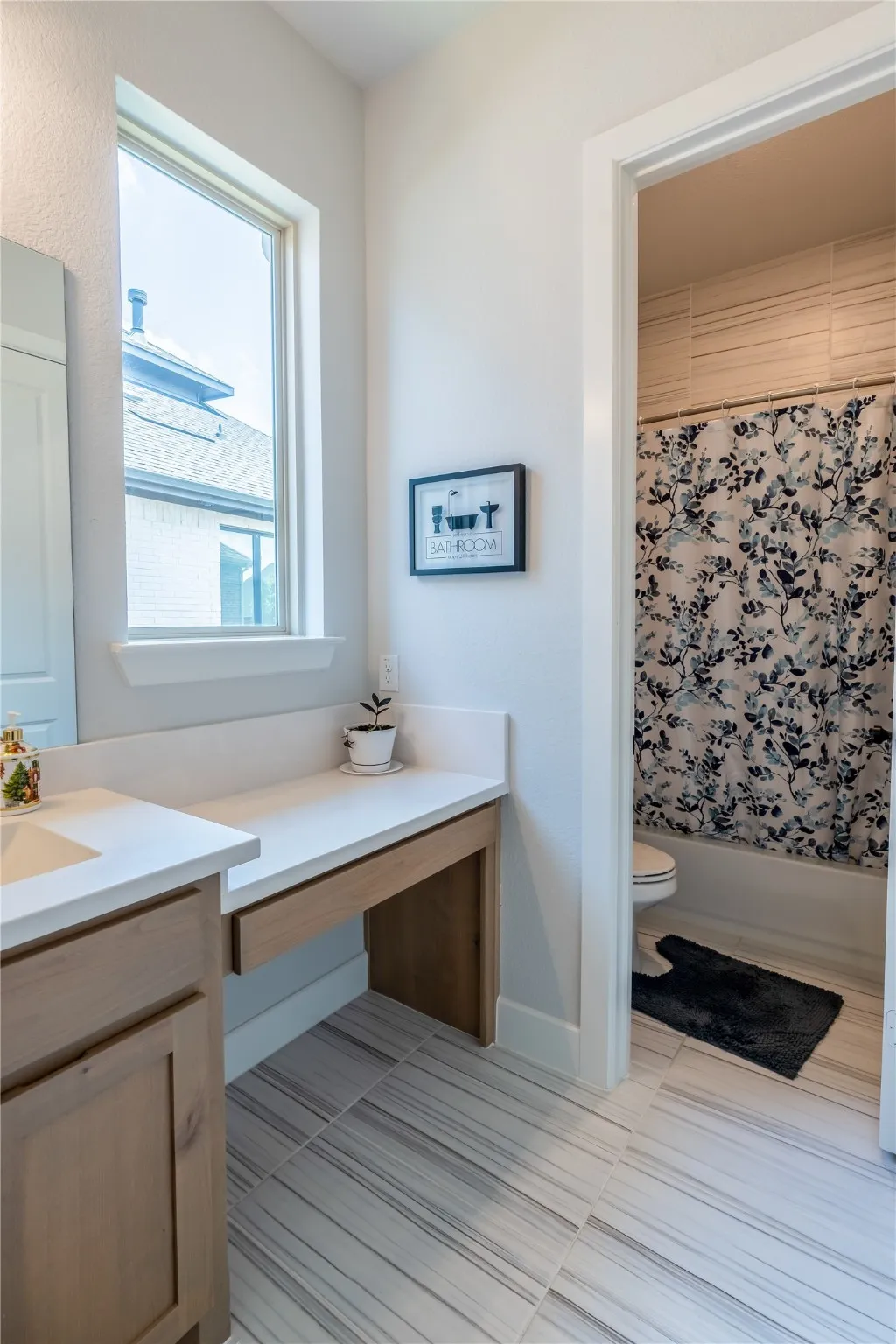 Full bathroom with vanity, shower / tub combo with curtain, and light tile patterned floors