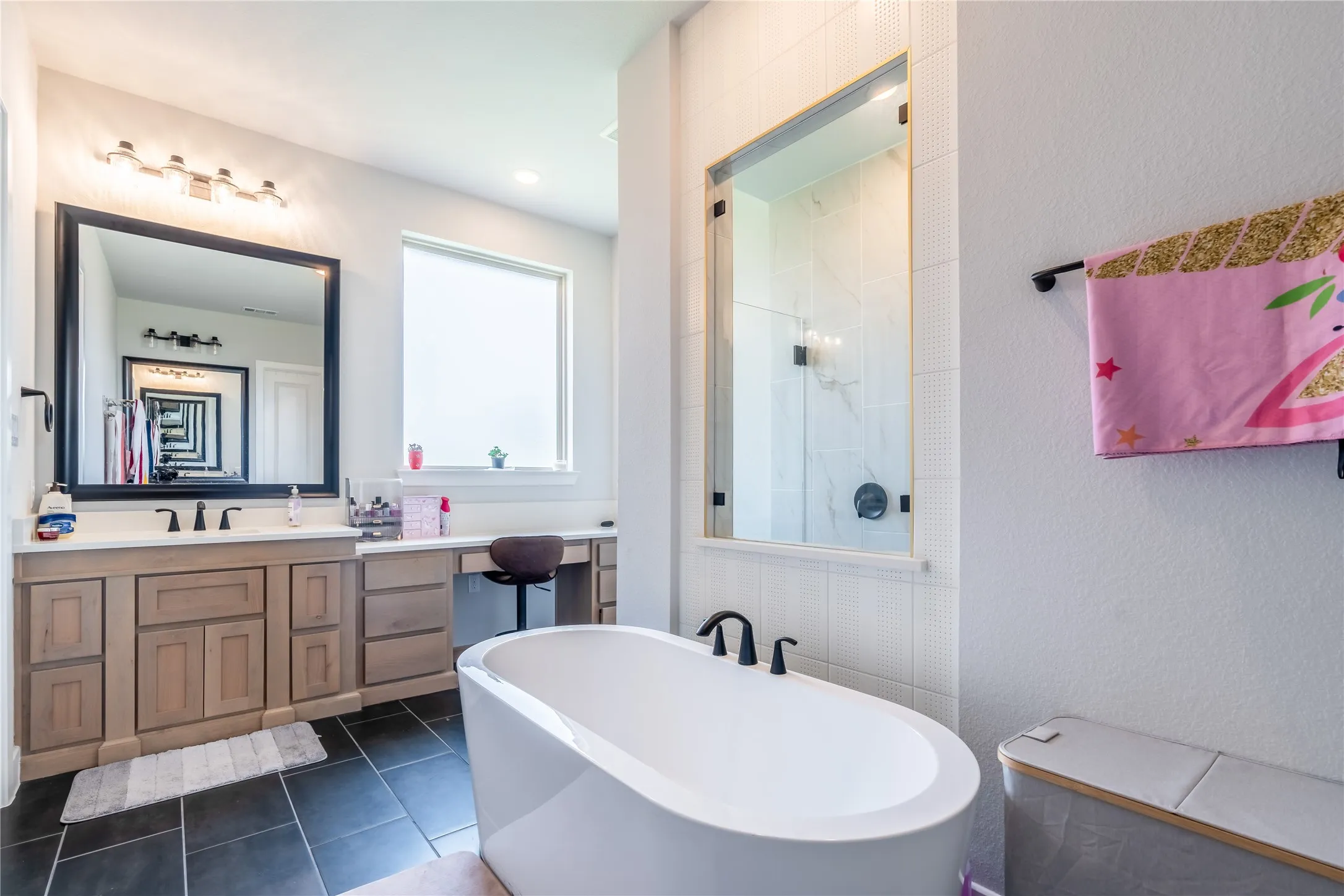 Full bath with a soaking tub, vanity, dark tile patterned flooring, a textured wall, and a walk in shower