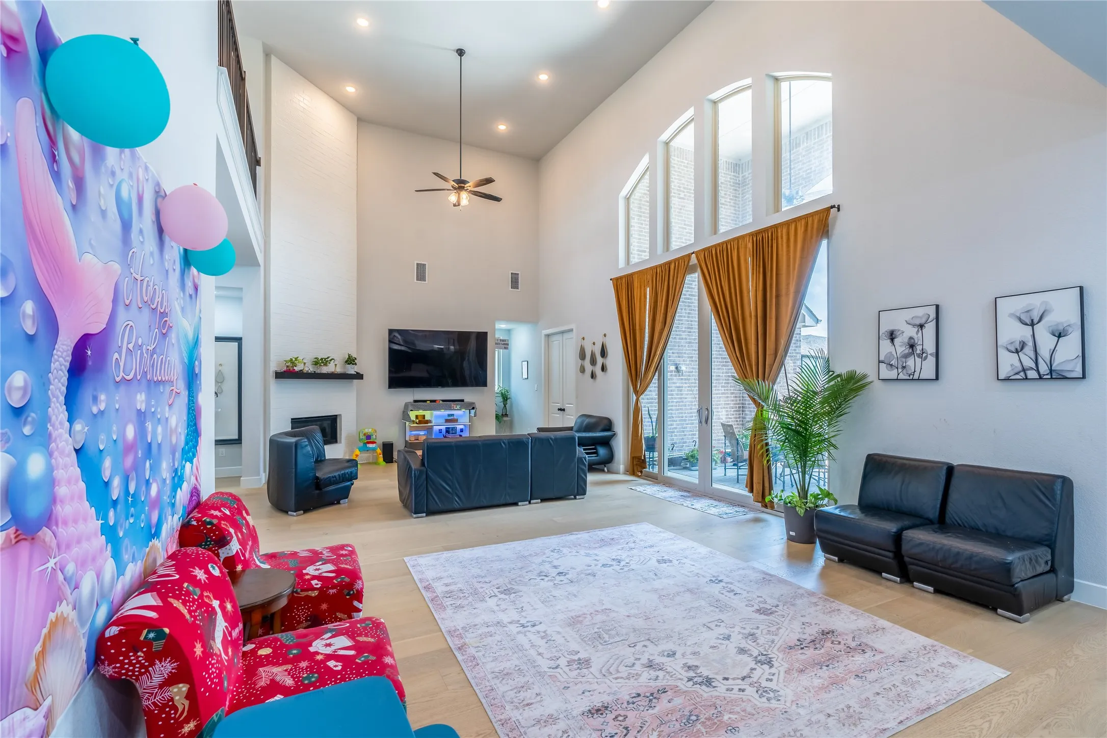 Living area featuring ceiling fan, light wood finished floors, a towering ceiling, and recessed lighting