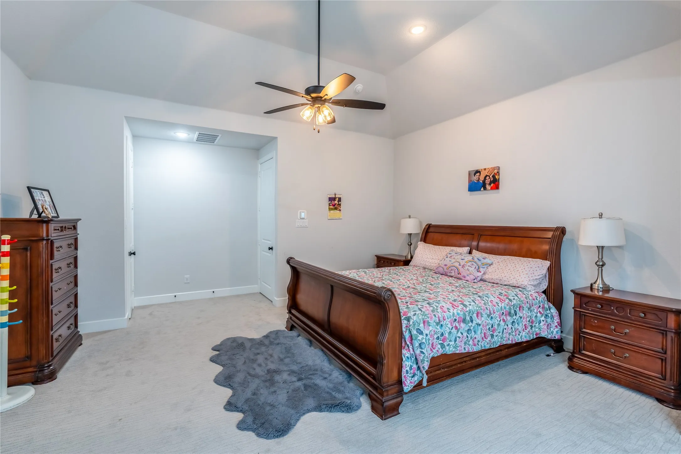 Bedroom with light colored carpet, ceiling fan, lofted ceiling, and recessed lighting