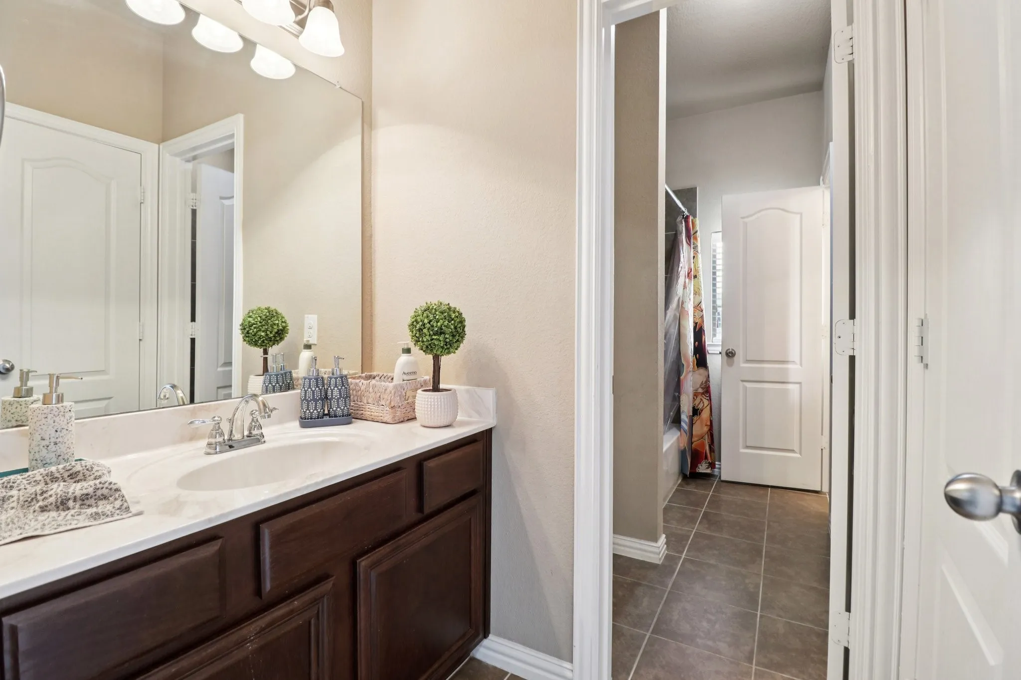 Full bath featuring shower / tub combo, vanity, and dark tile patterned flooring