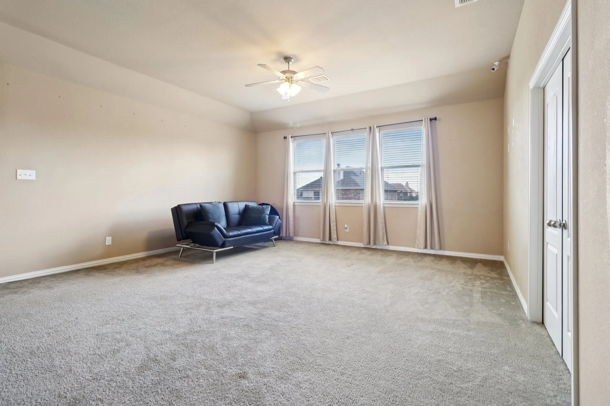 Sitting room with light carpet and a ceiling fan