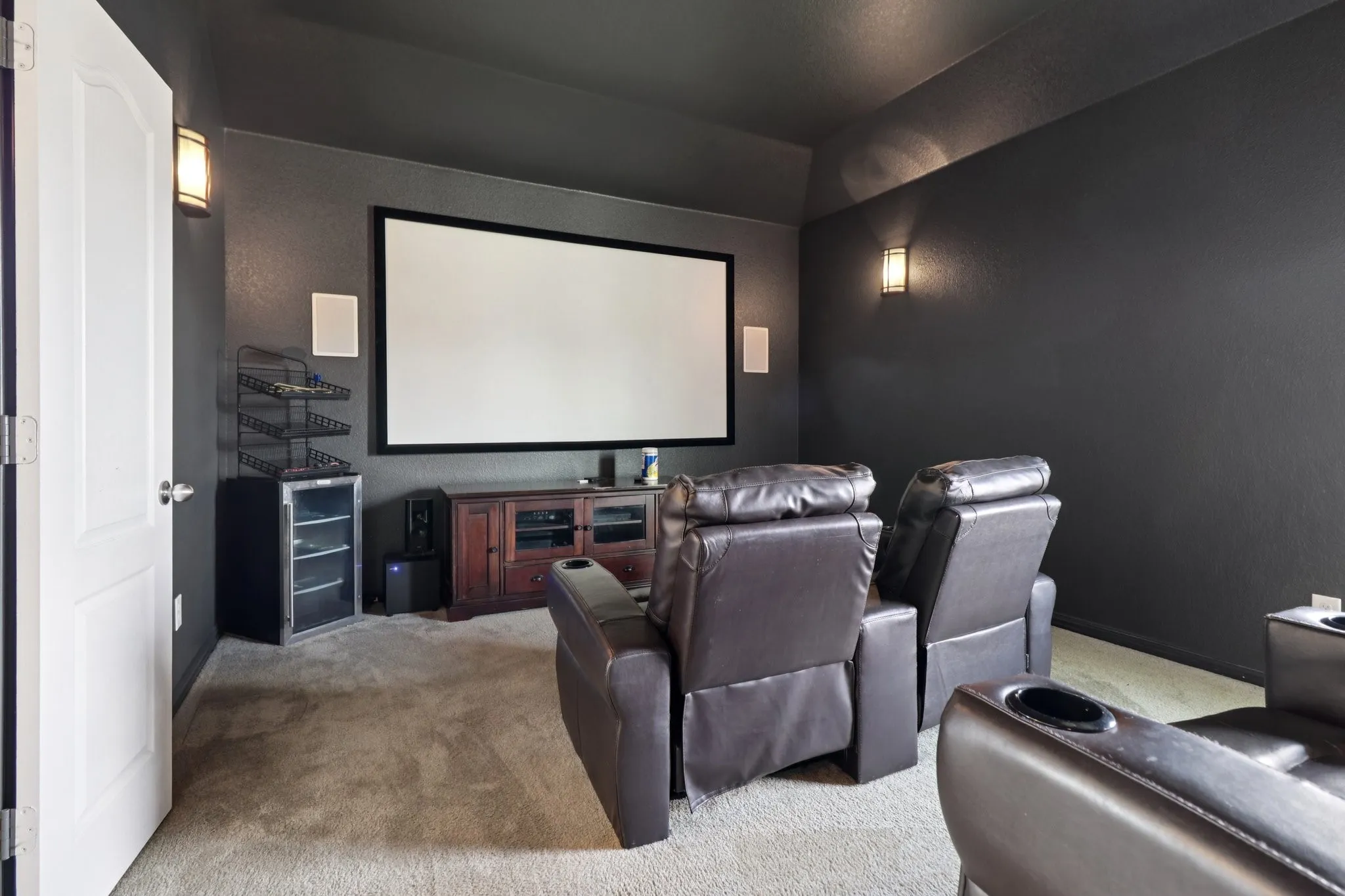 Carpeted home theater featuring baseboards and a textured wall