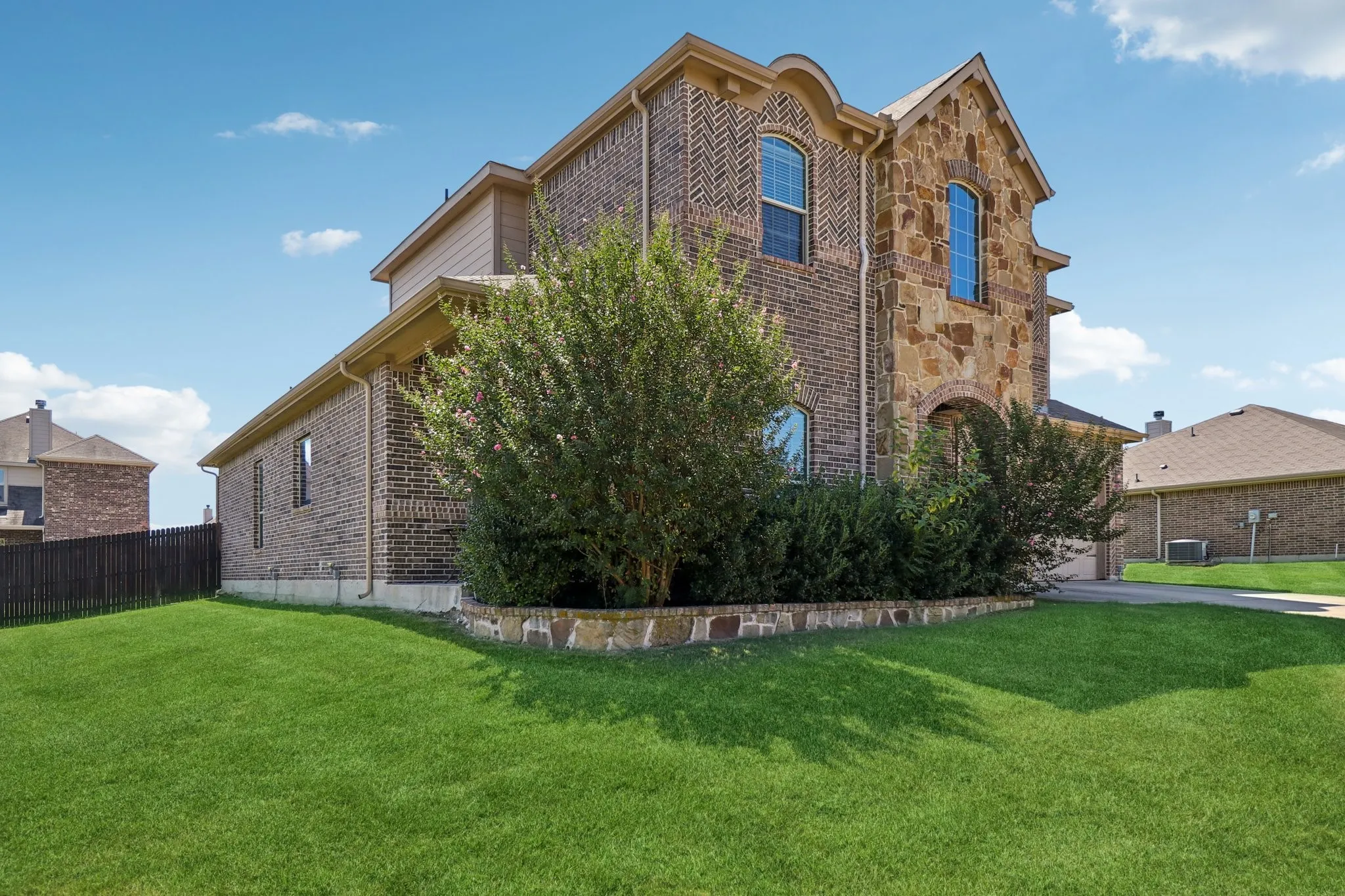 View of property exterior with brick siding and stone siding