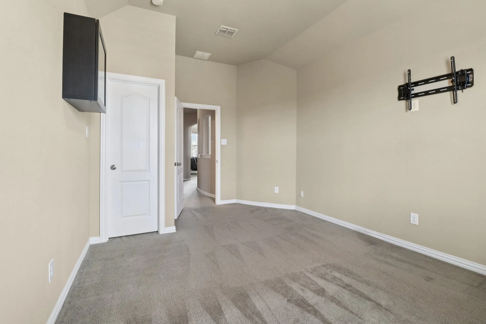 Unfurnished room with carpet and vaulted ceiling