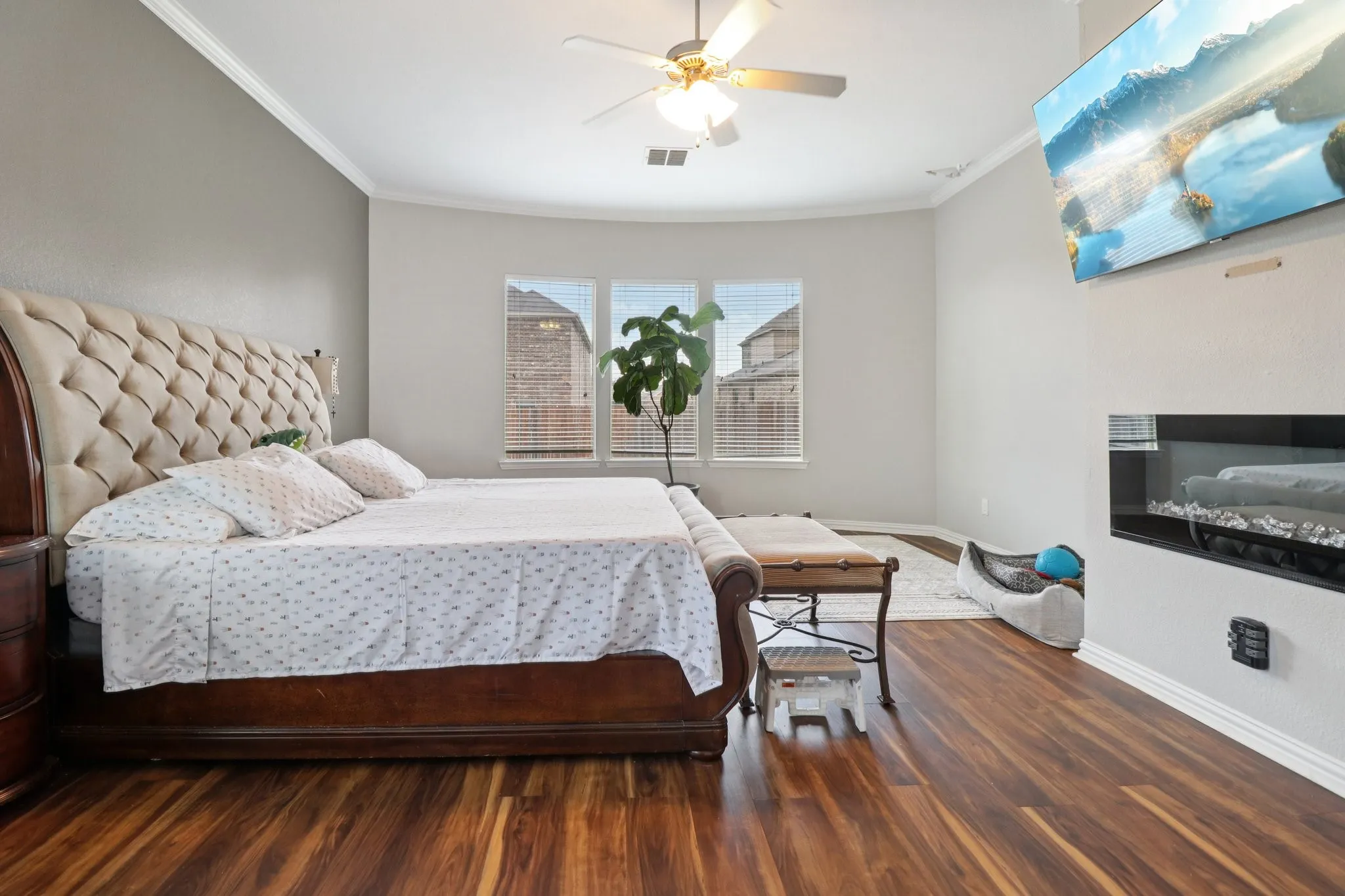 Bedroom with crown molding, dark wood-style floors, and a ceiling fan