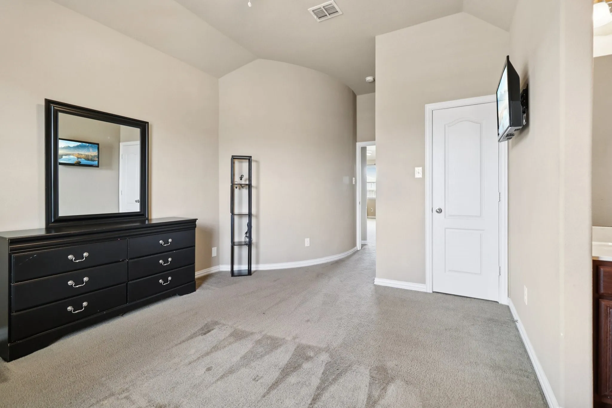 Unfurnished bedroom with vaulted ceiling and carpet flooring