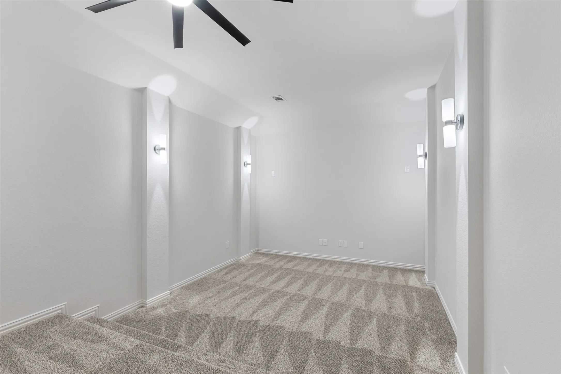 Spare room with baseboards, light carpet, and ceiling fan