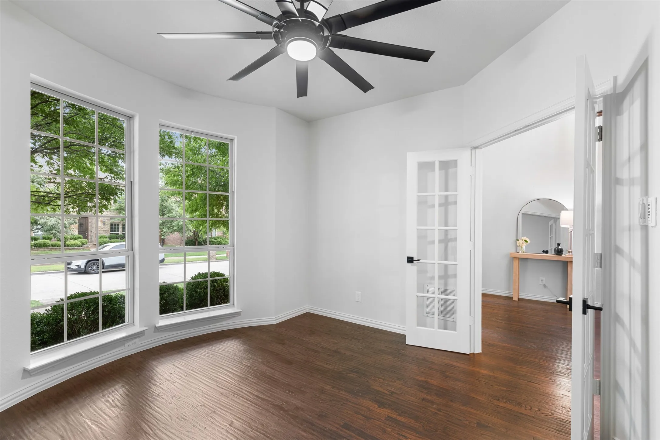 Unfurnished room with dark wood-style flooring, french doors, a ceiling fan, and baseboards