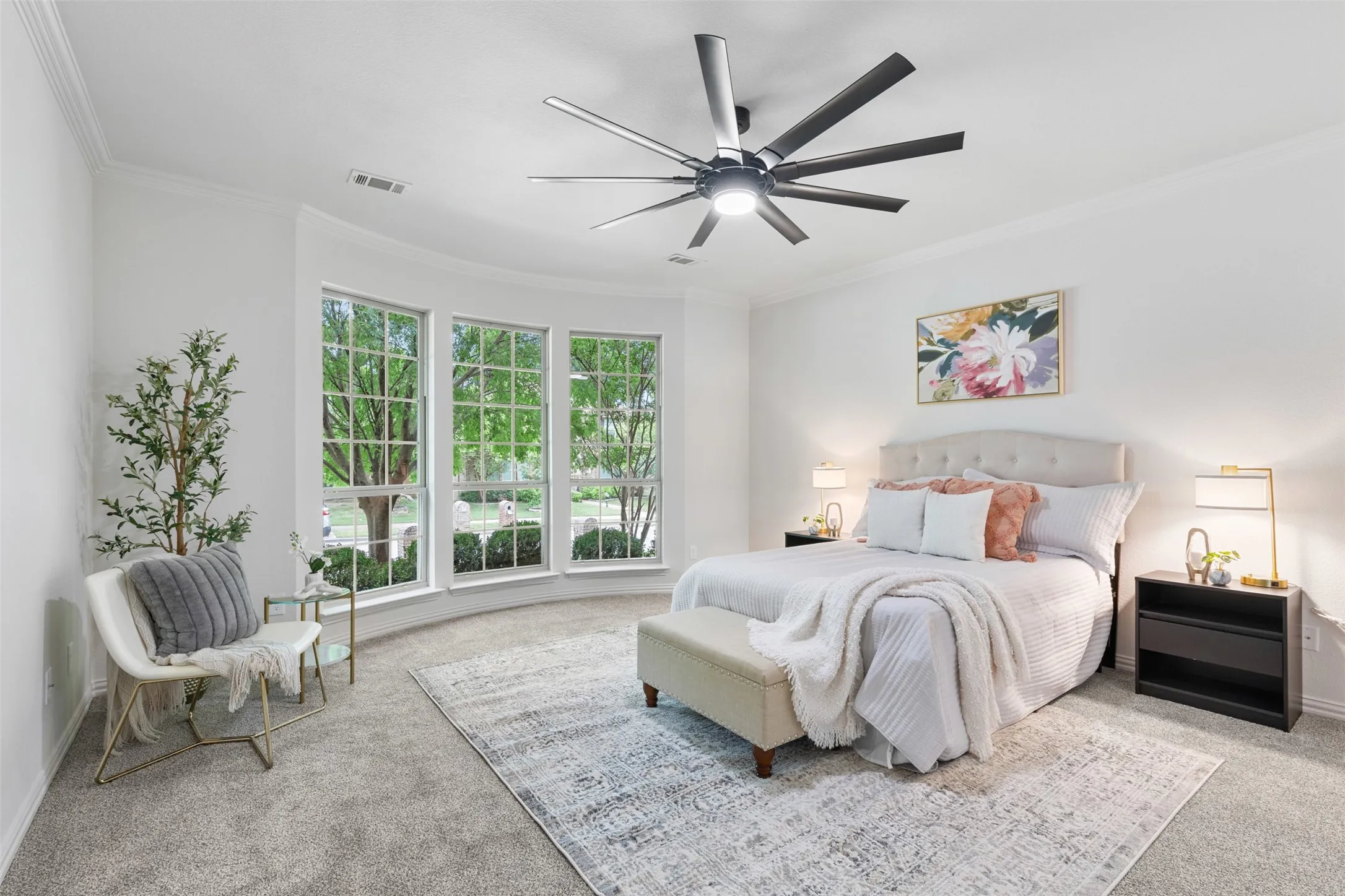 Carpeted bedroom with baseboards, visible vents, ceiling fan, and crown molding